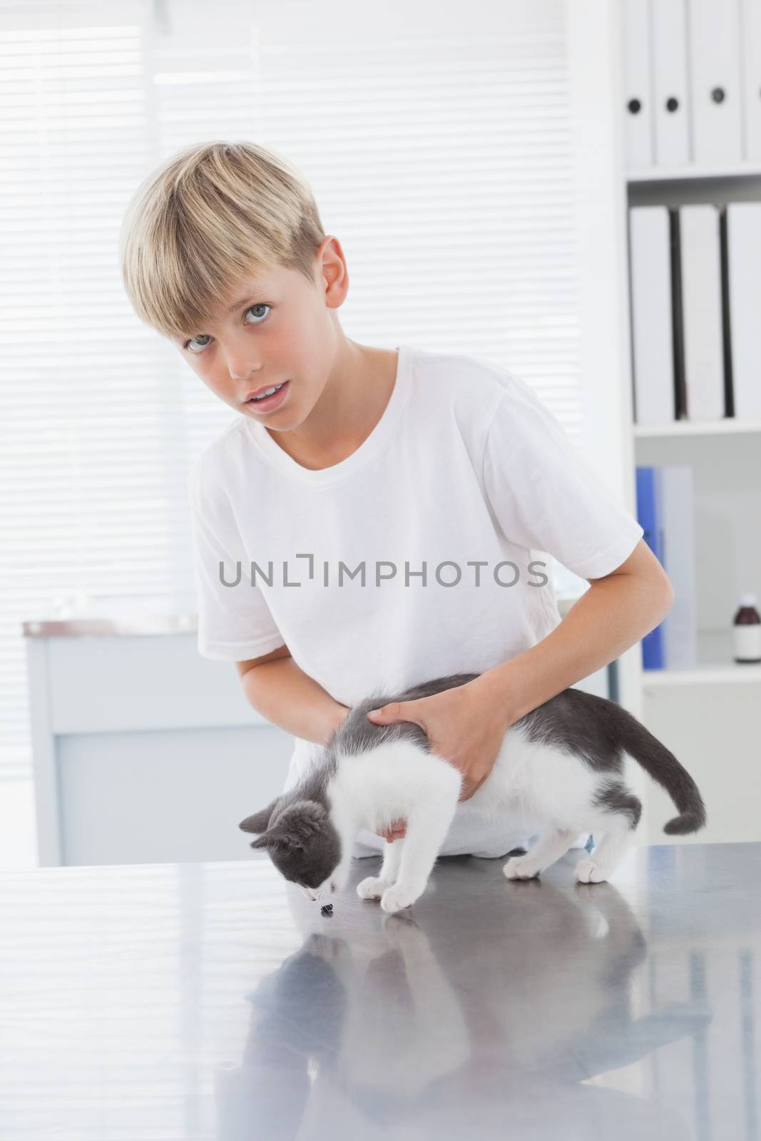 Smiling owner holding his cat in medical office