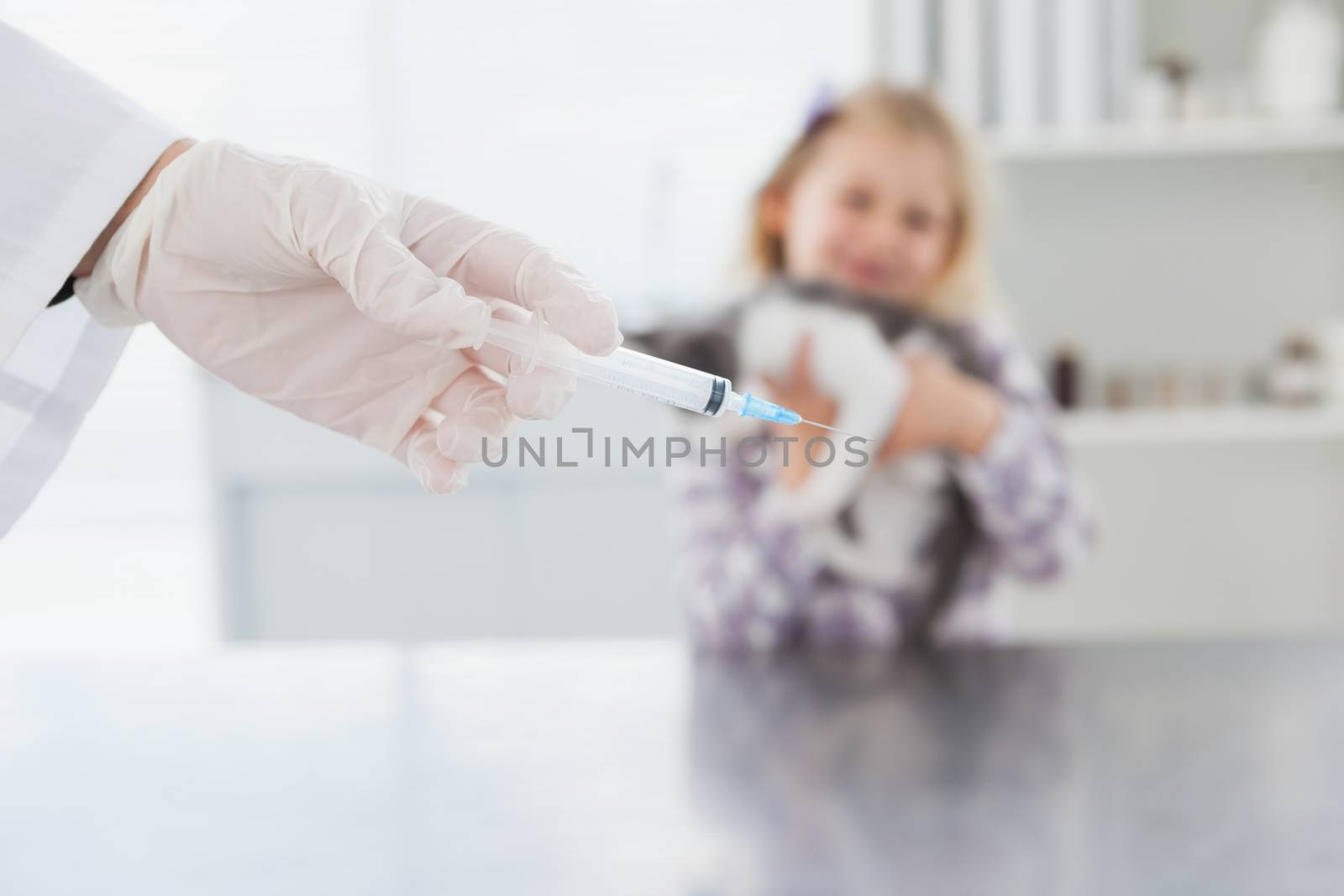 Veterinarian doing injecting at a cute kitten in medical office