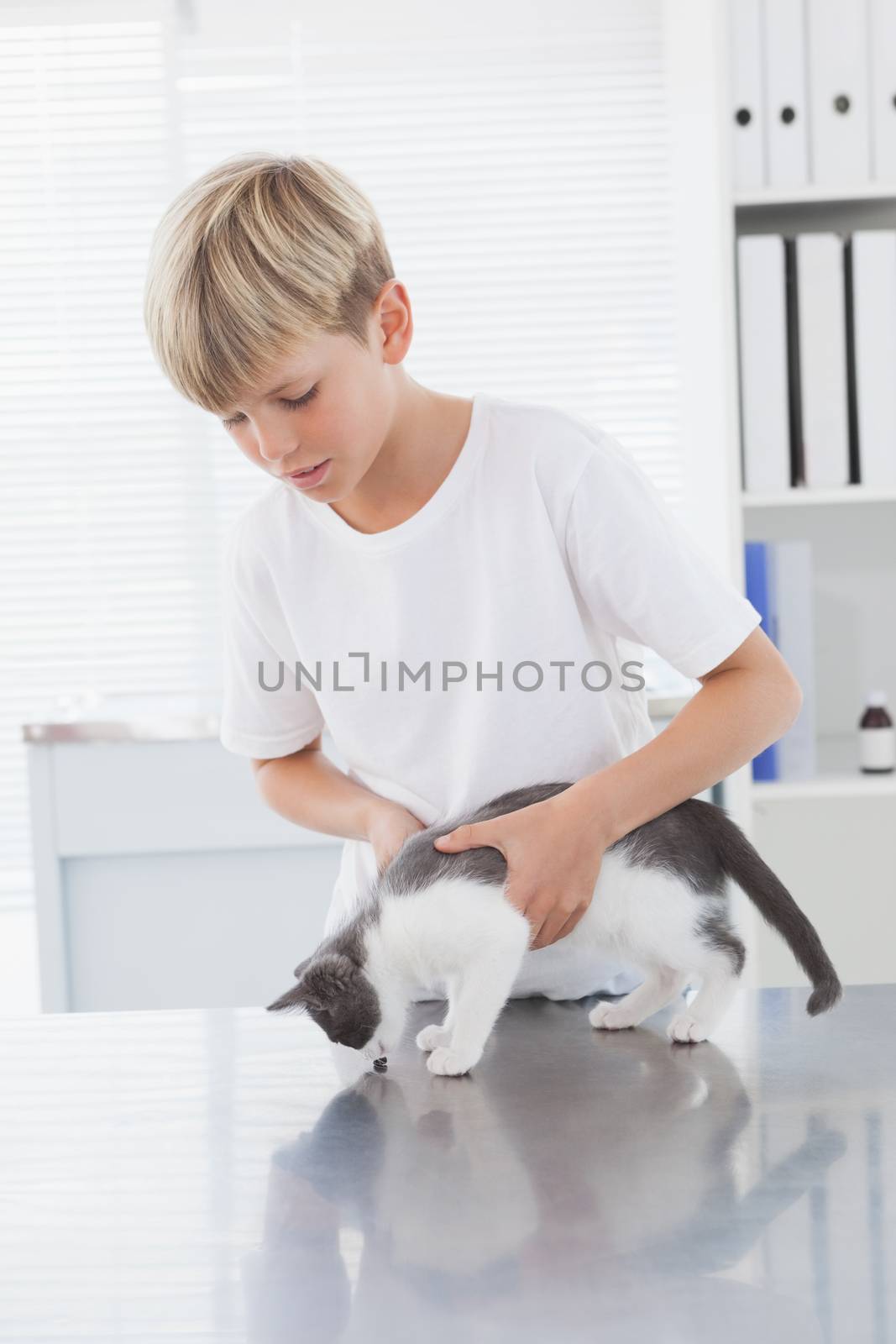 Smiling owner holding his cat in medical office