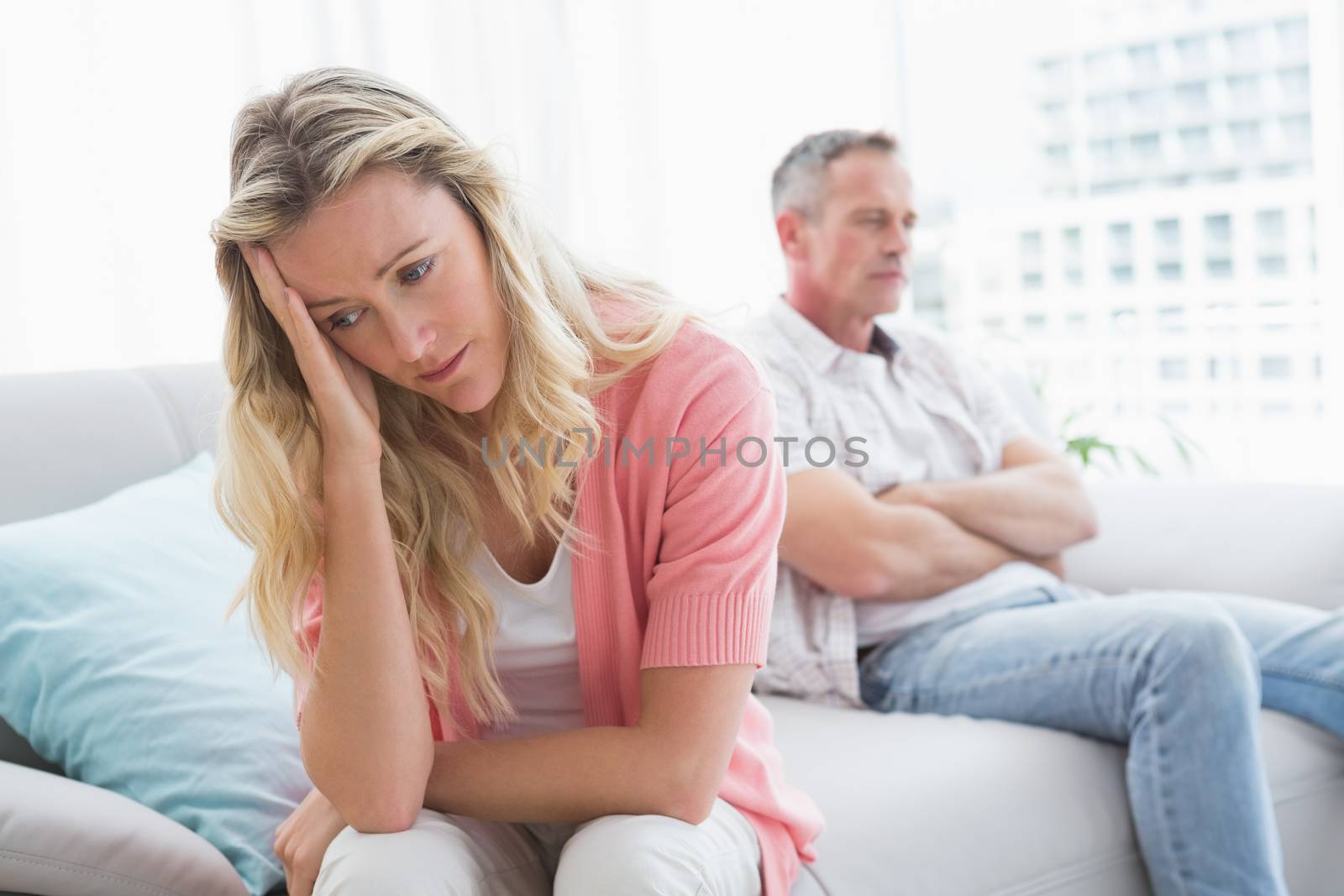 Unhappy couple are stern and having troubles at home in the living room