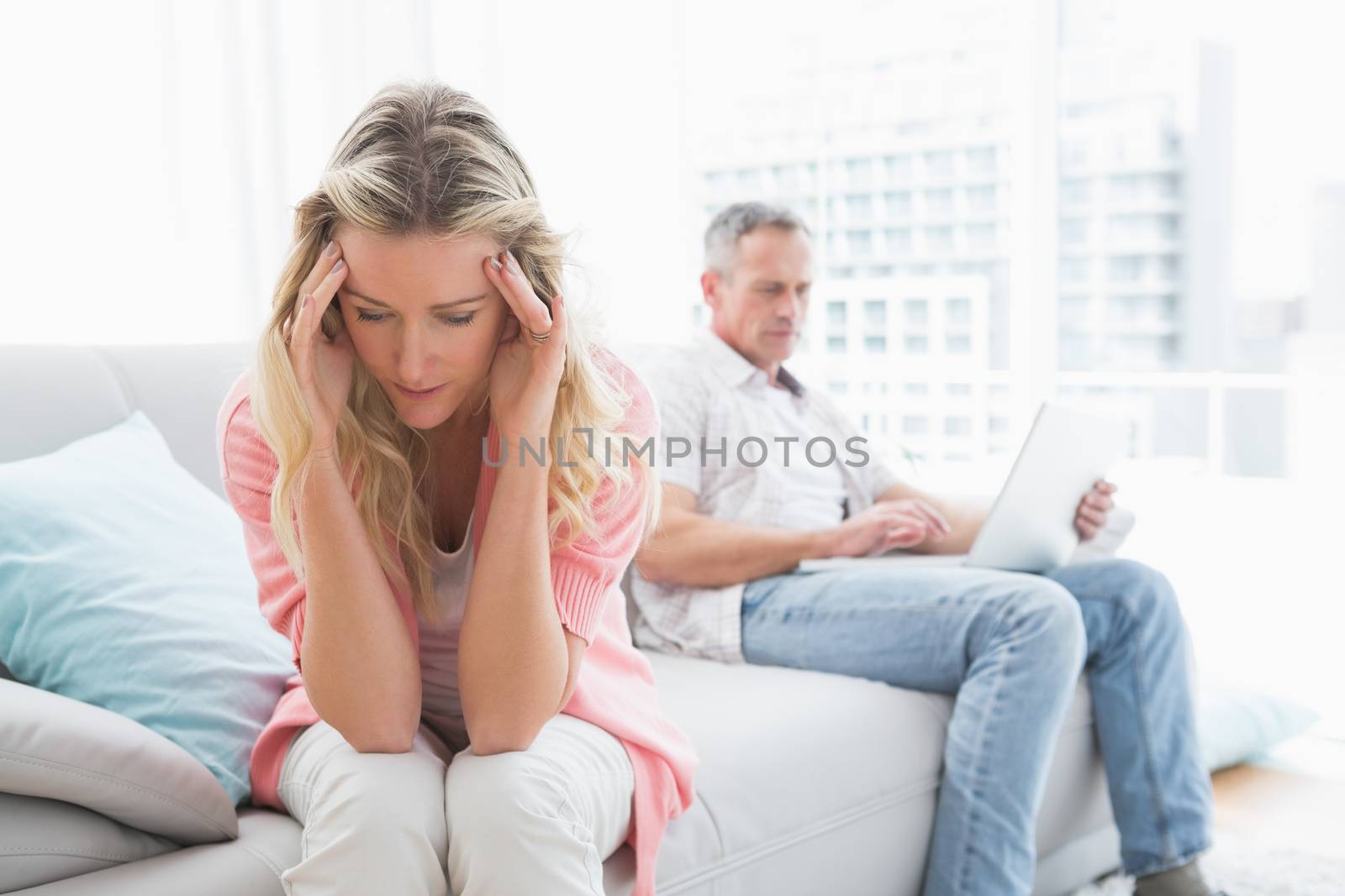 Unhappy couple are stern and having troubles at home in the living room