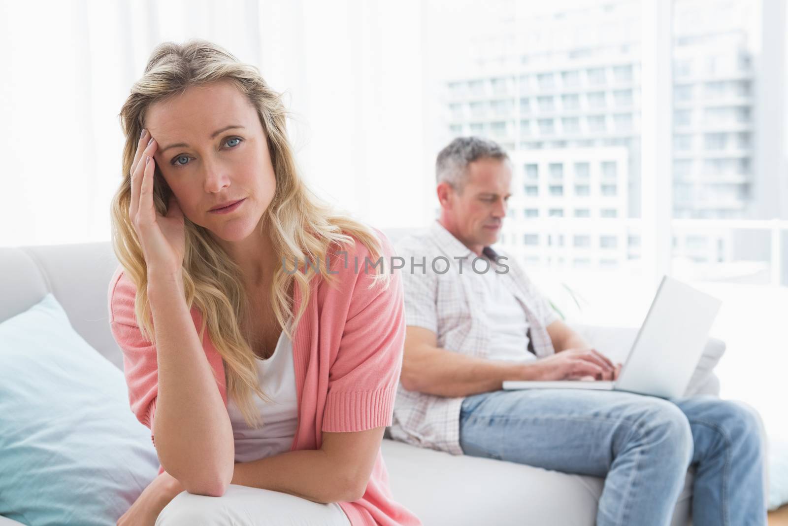 Unhappy couple are stern and having troubles at home in the living room
