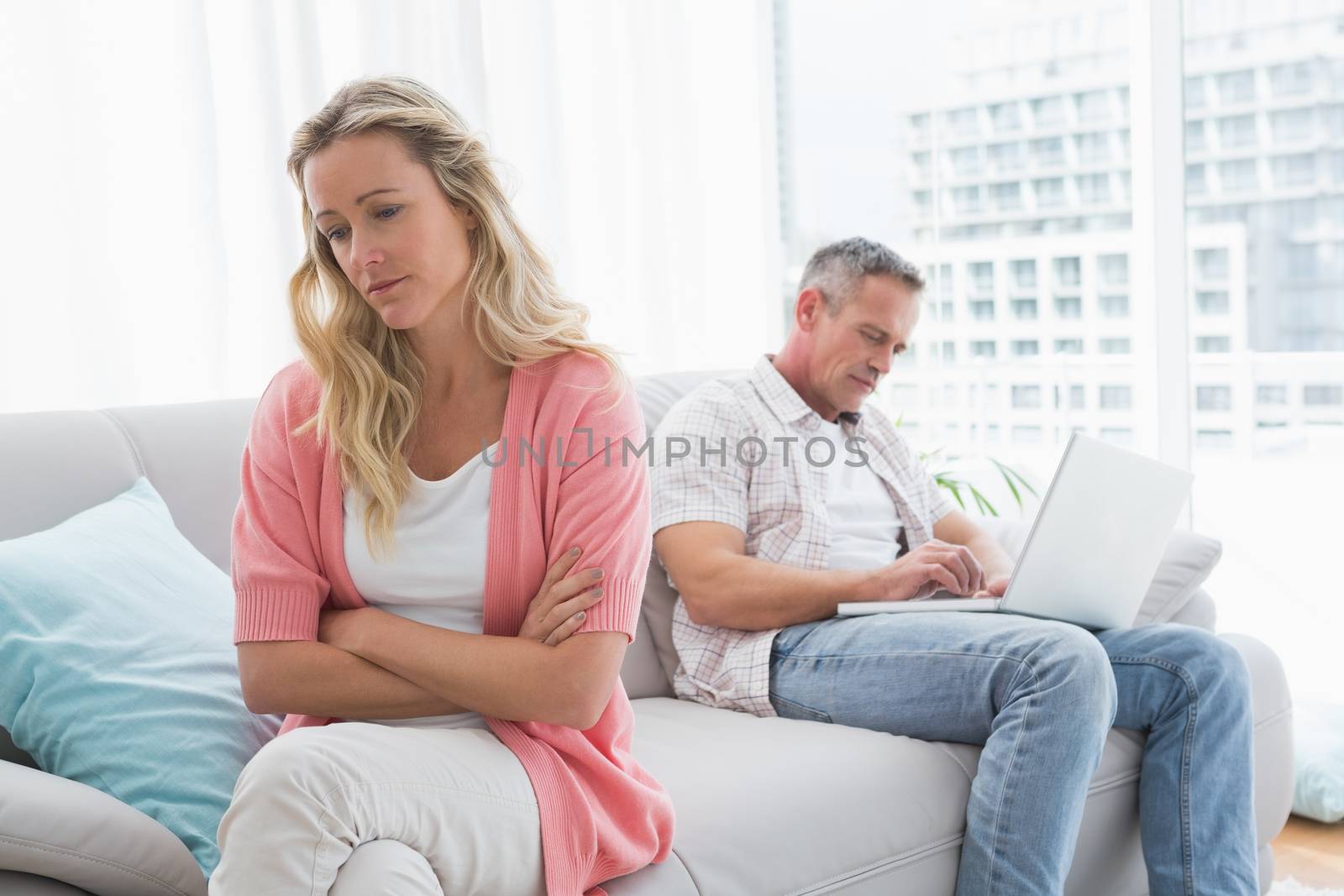 Unhappy couple are stern and having troubles at home in the living room