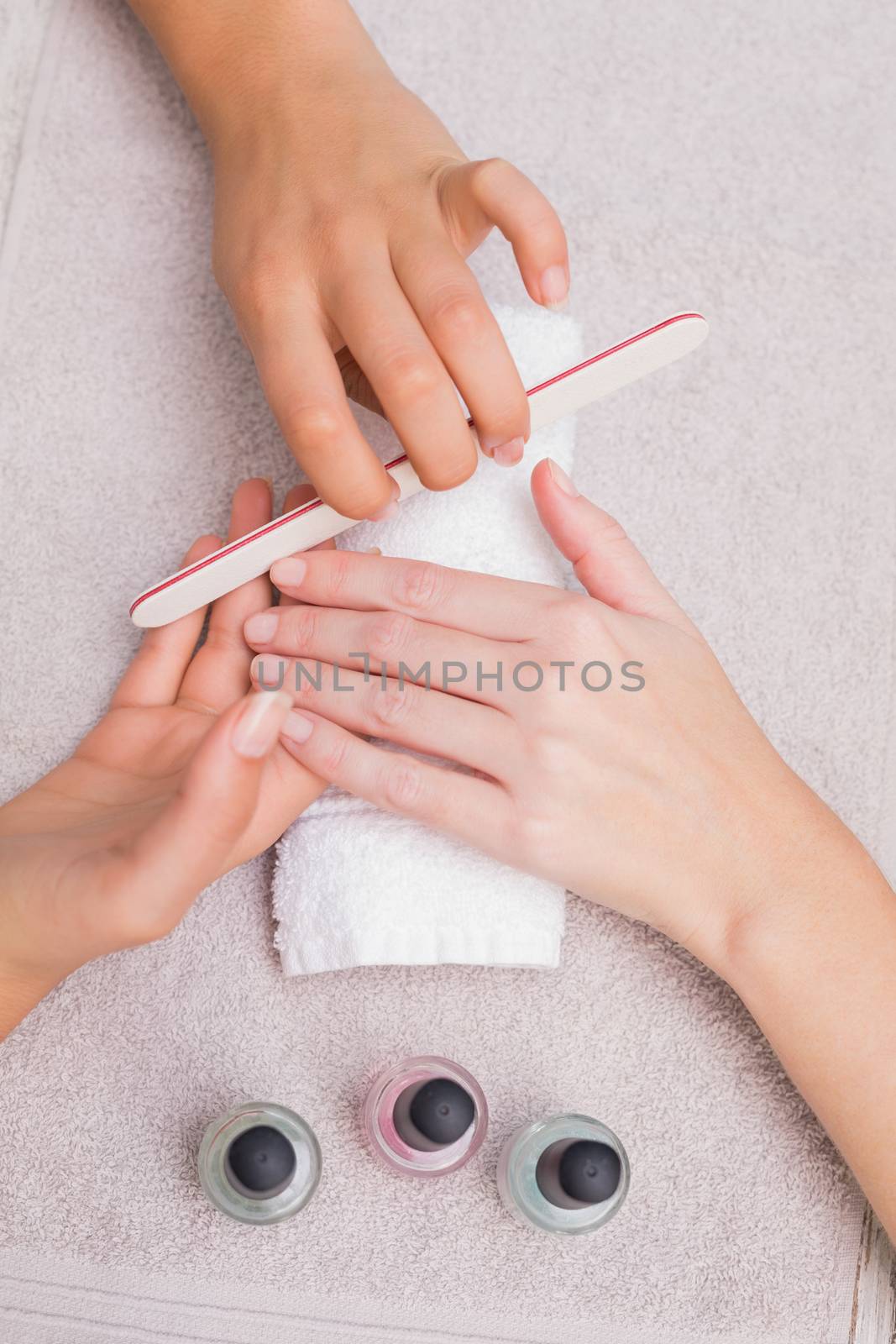 Nail technician giving customer a manicure at the beauty salon