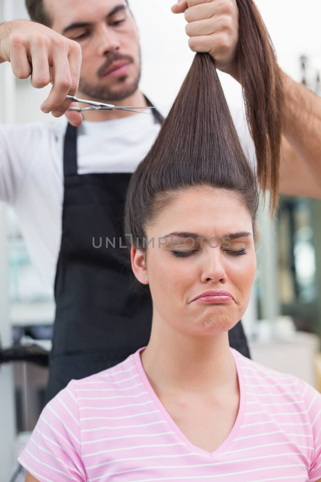 Sad brunette getting her hair cut by Wavebreakmedia