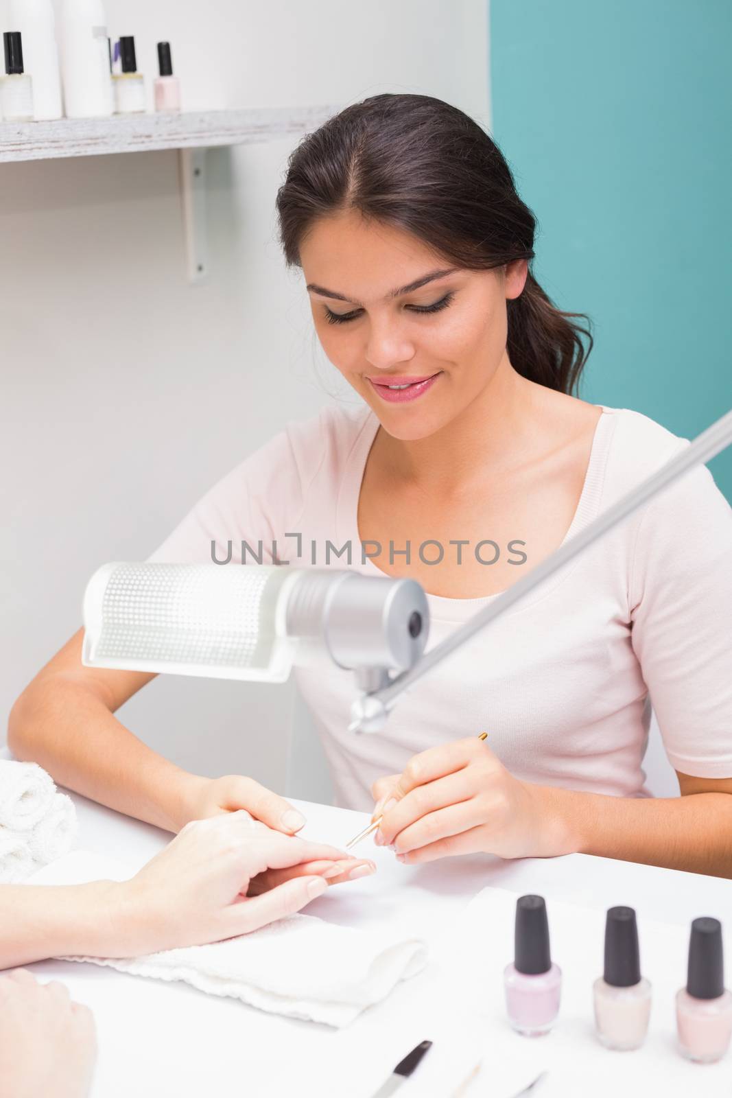 Nail technician giving customer a manicure by Wavebreakmedia