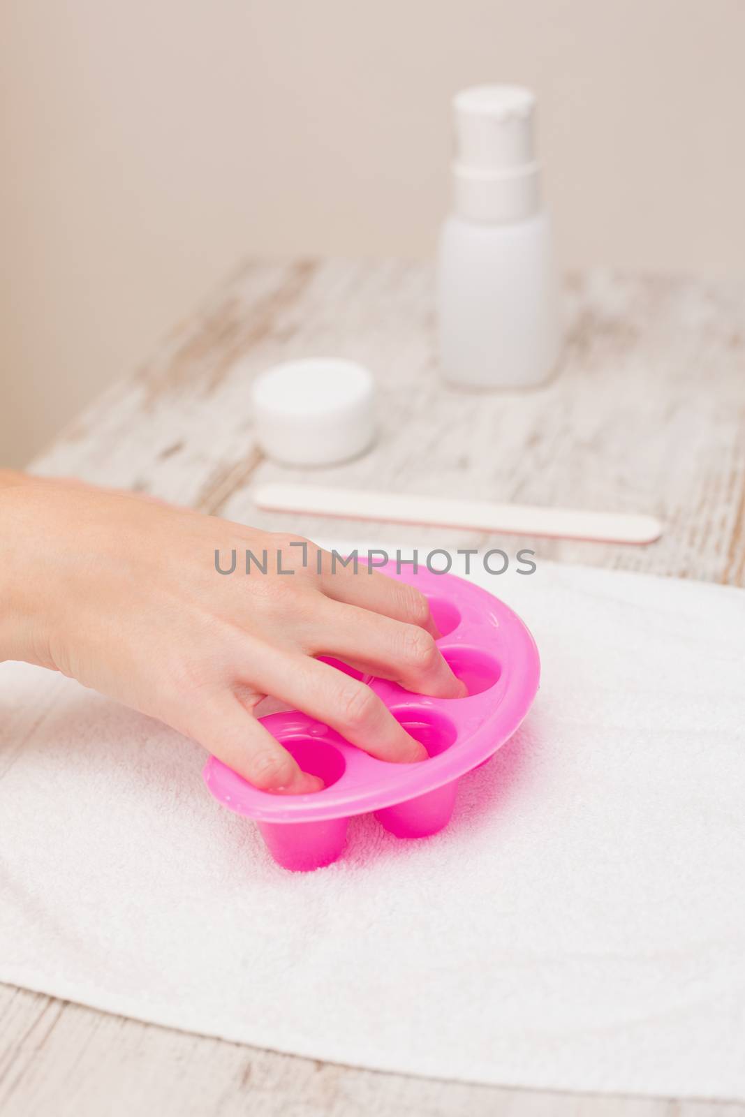 Woman soaking her nails in nail bowls by Wavebreakmedia