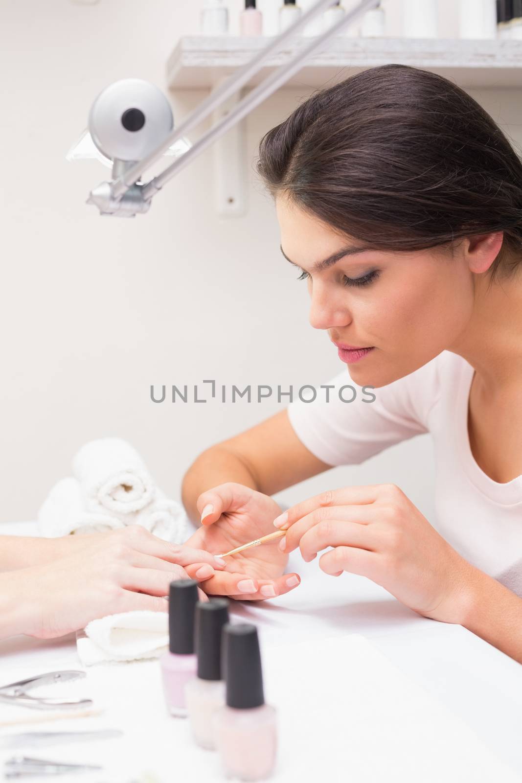 Nail technician giving customer a manicure at the beauty salon