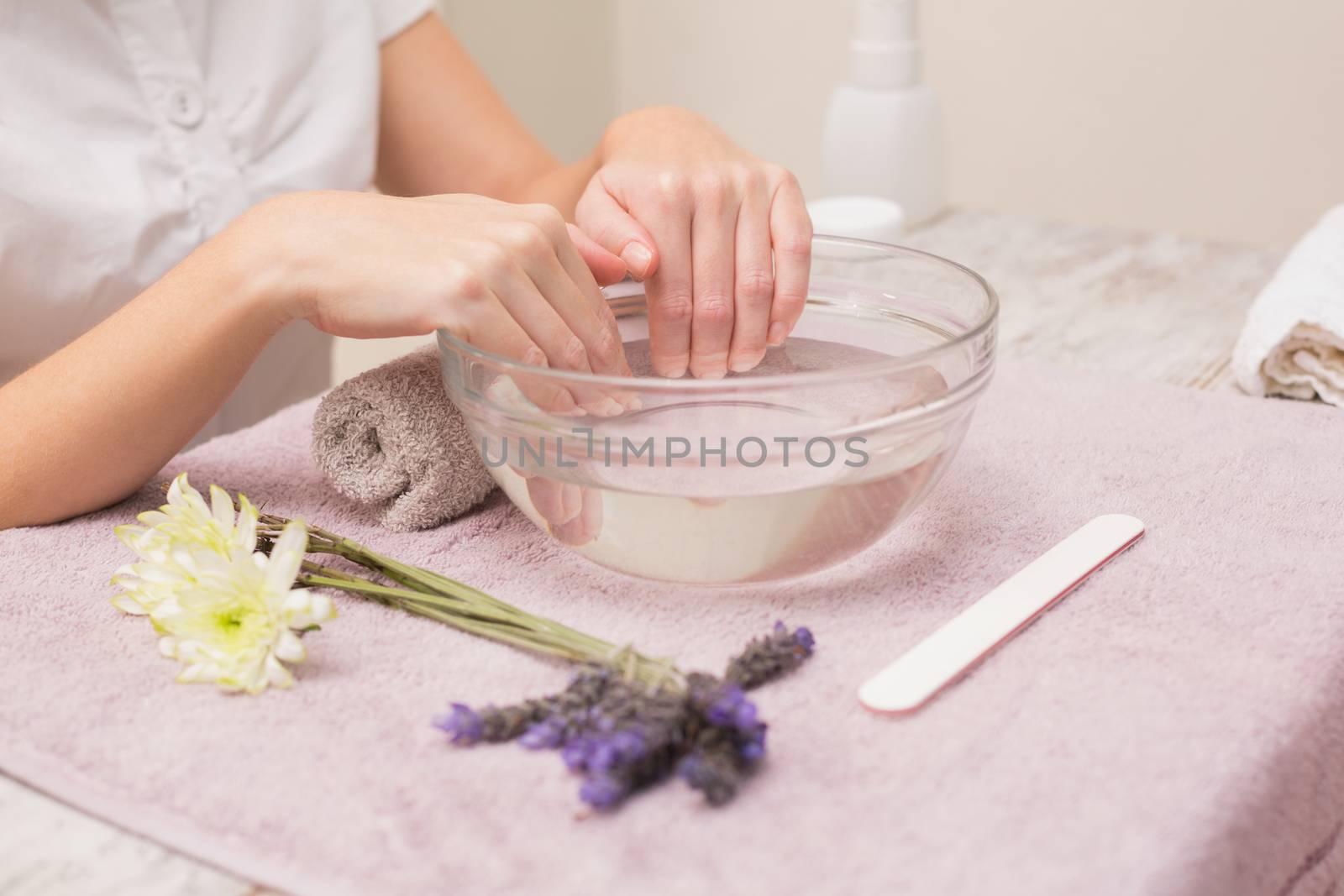 Woman soaking her nails in water bowl by Wavebreakmedia