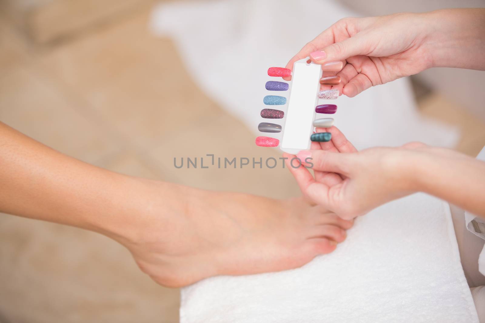 Beautician showing client nail colours at the beauty salon