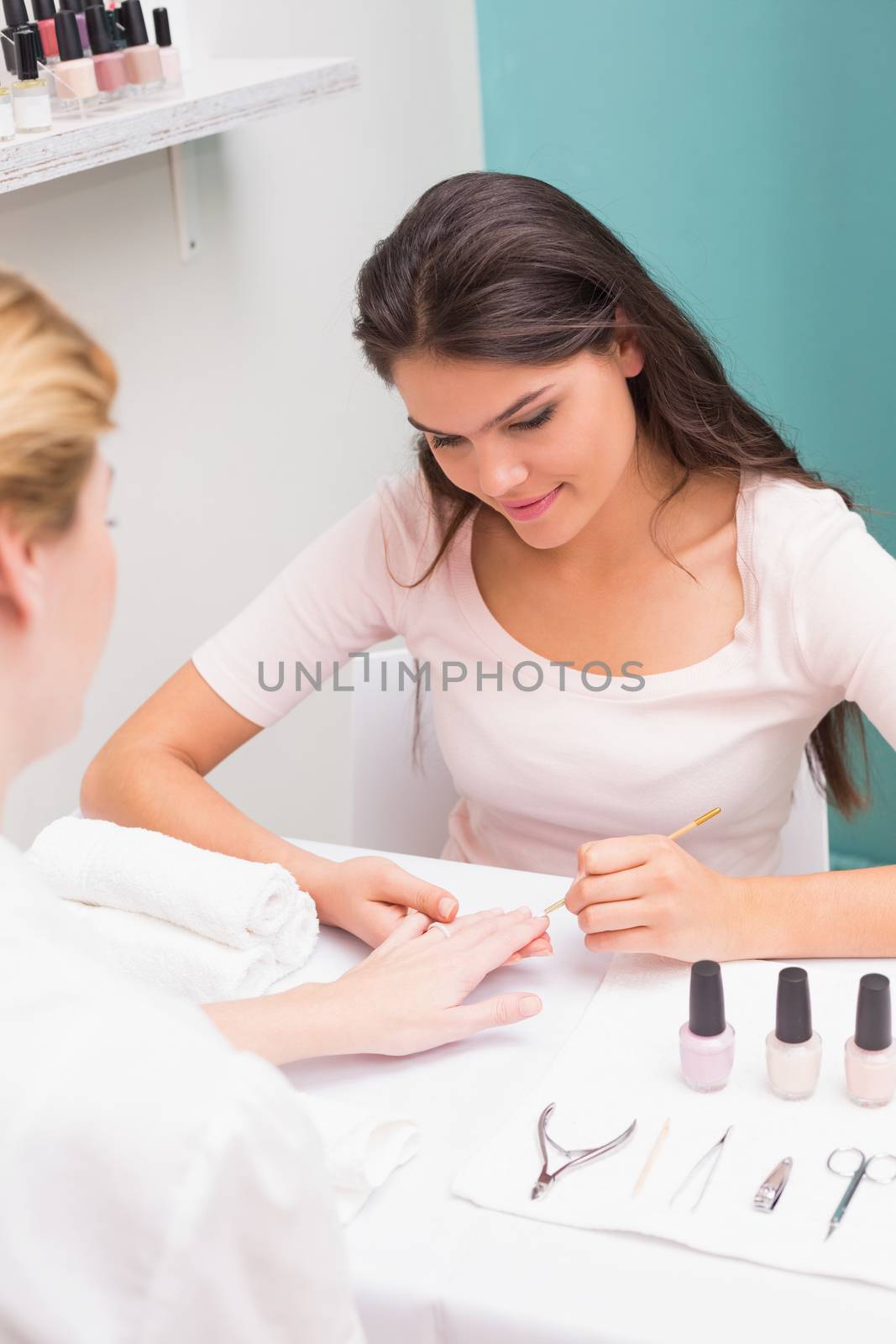 Nail technician giving customer a manicure at the beauty salon