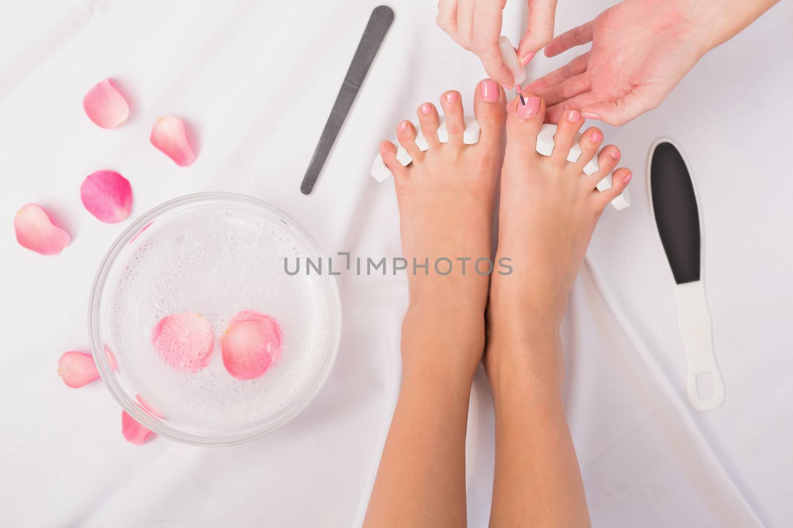 Beautician painting womans toenails by Wavebreakmedia
