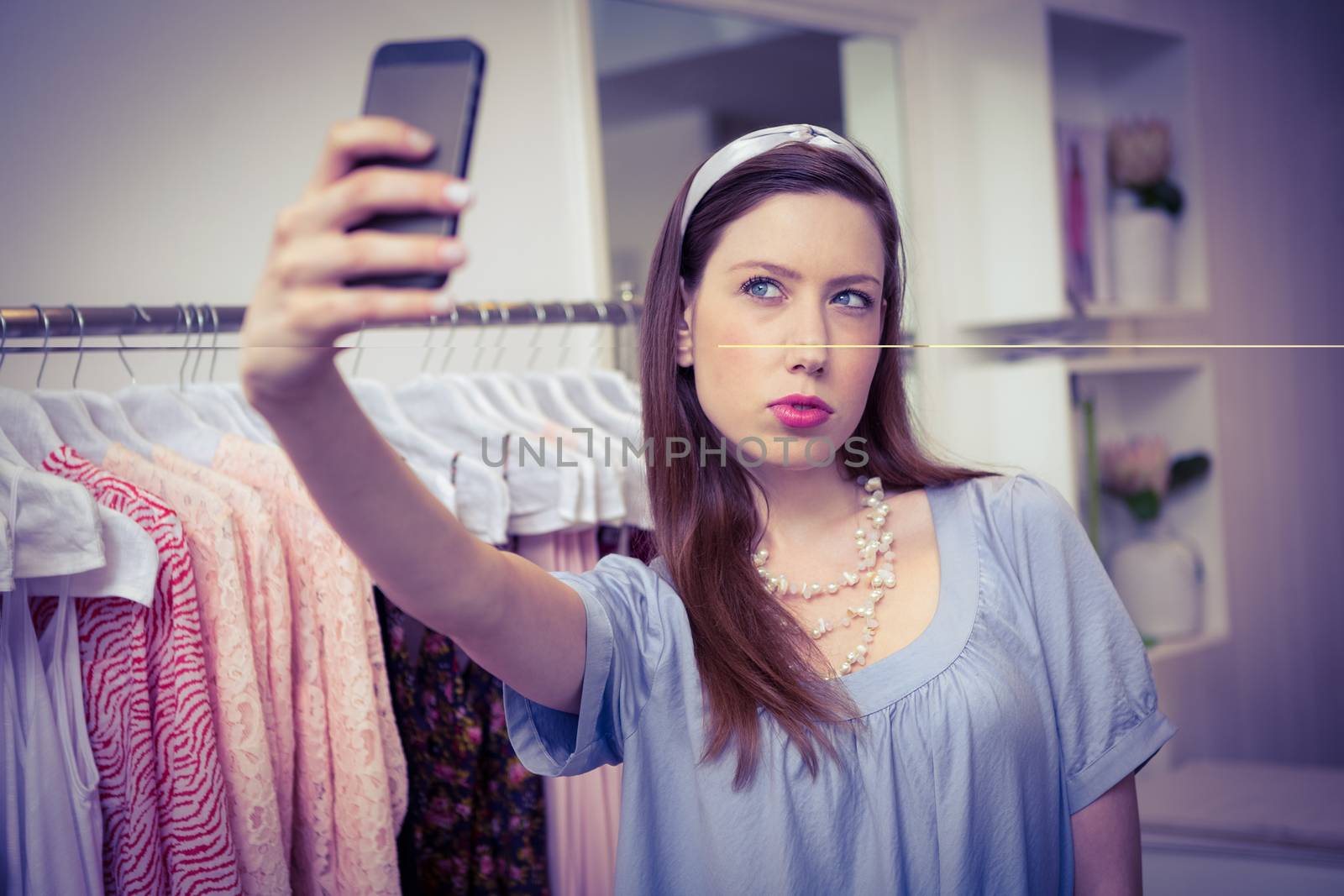 Brunette taking a selfie in fashion boutique