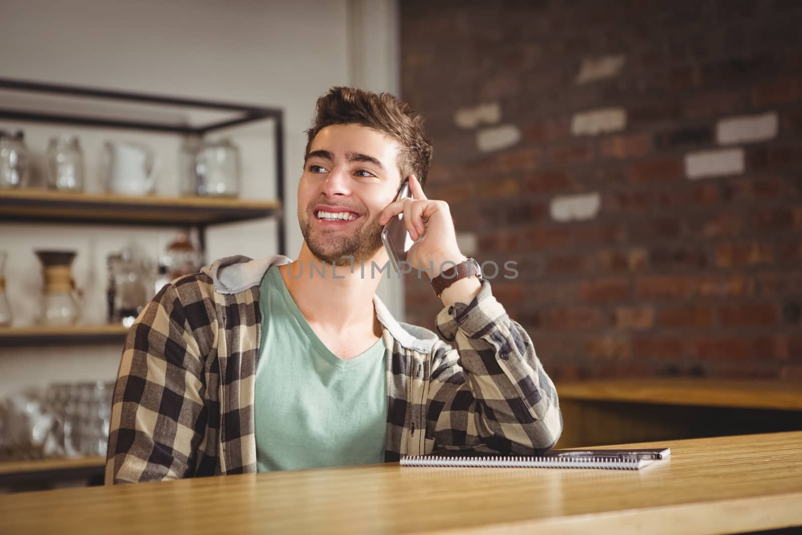 Smiling hipster phoning with smartphone by Wavebreakmedia