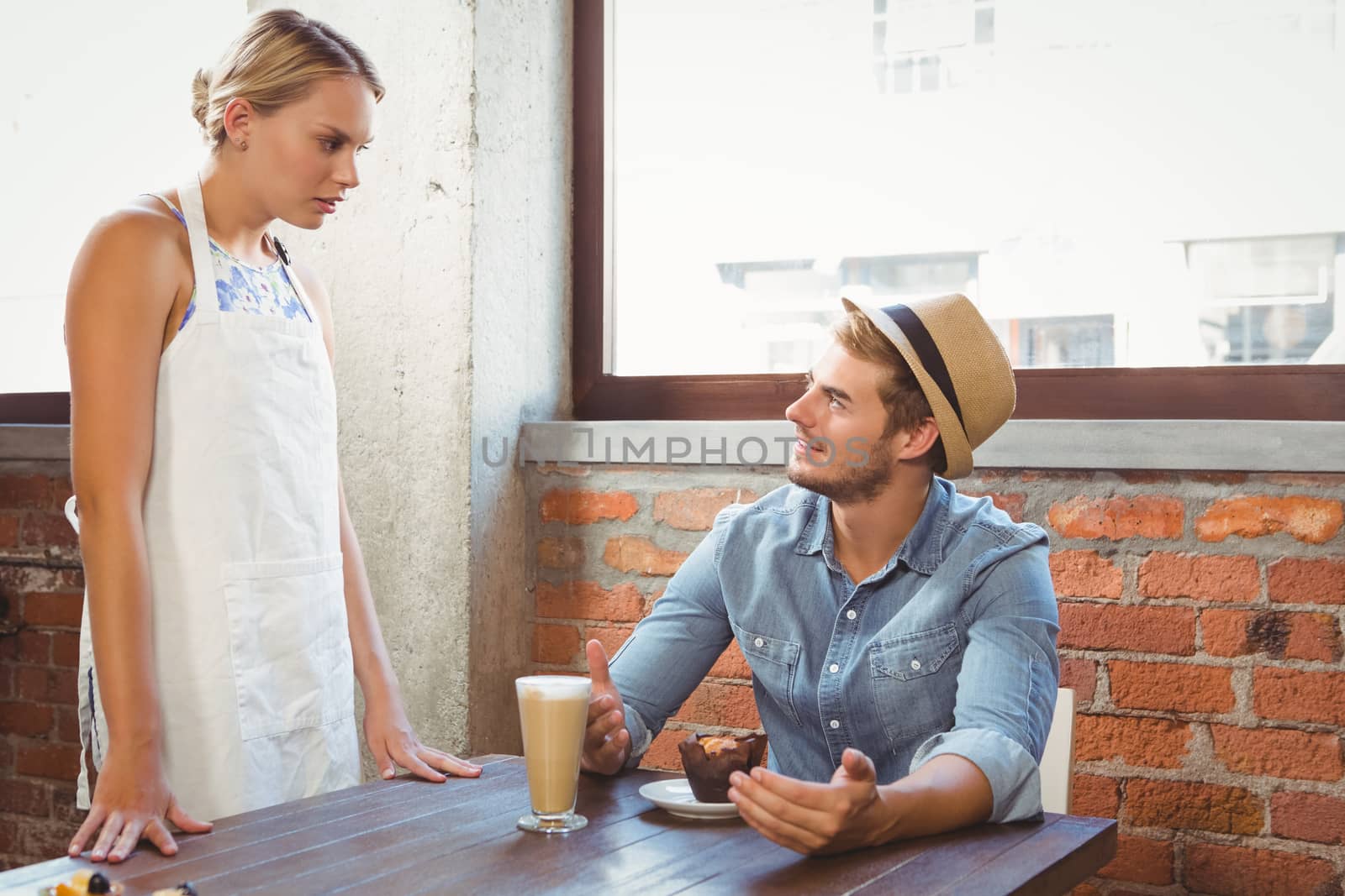 Handsome hipster talking to blonde waitress by Wavebreakmedia