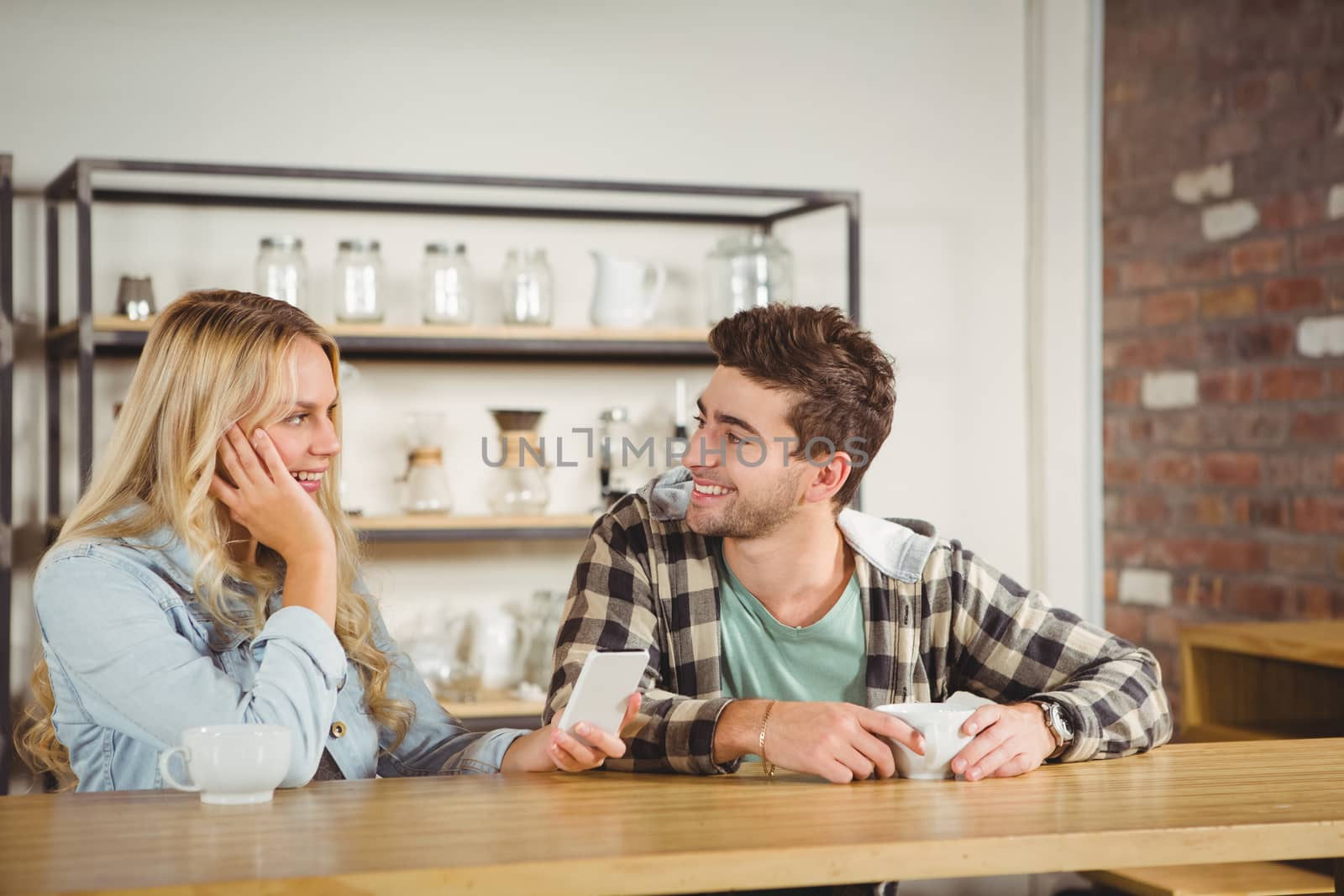 Smiling hipsters sitting and talking by Wavebreakmedia