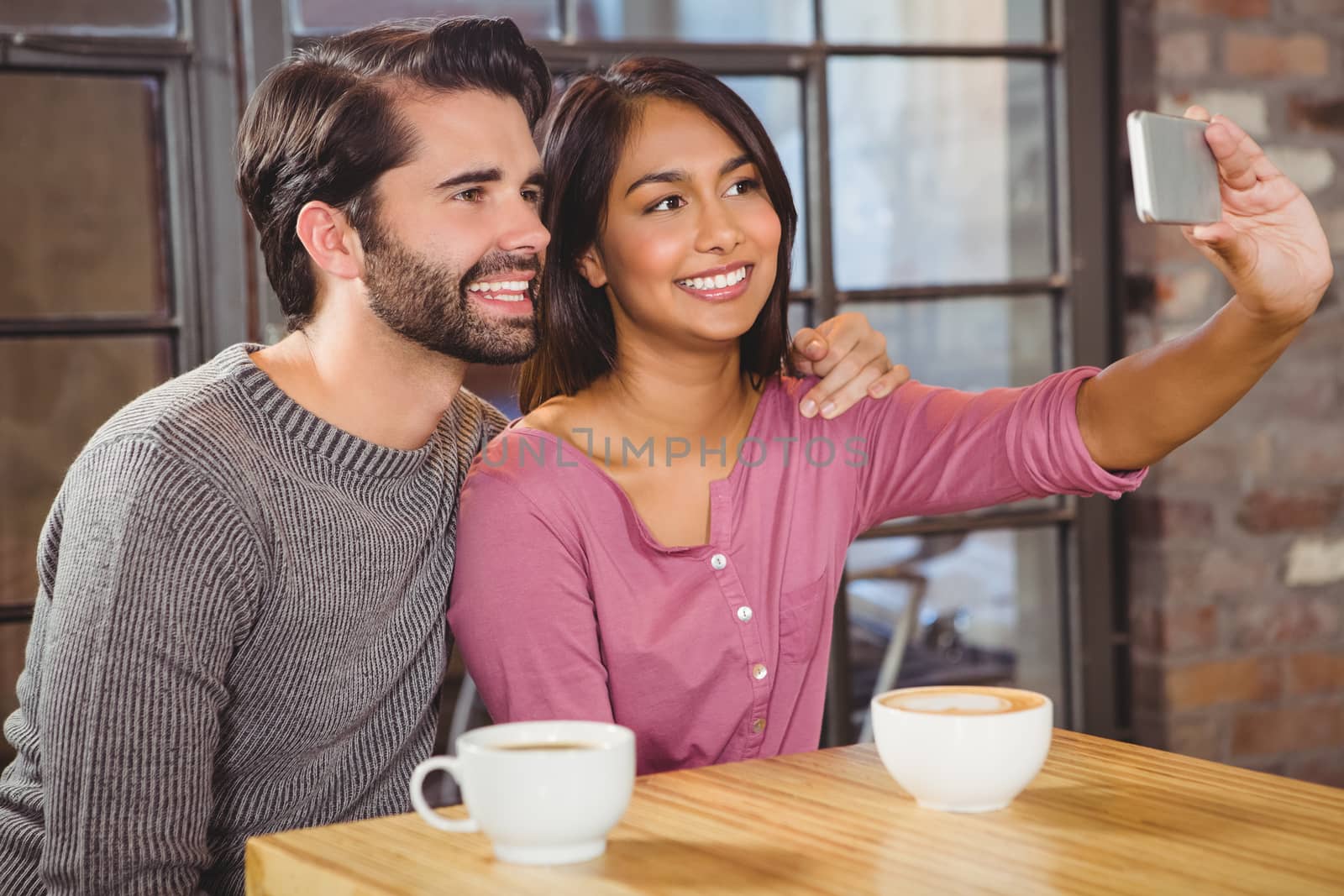 Cute couple taking selfie in a cafe