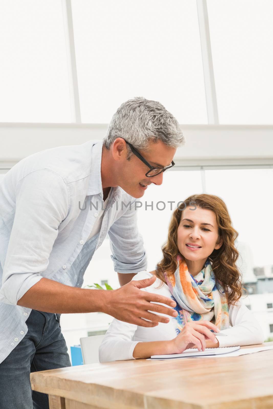 Casual designer briefing his colleague in the office