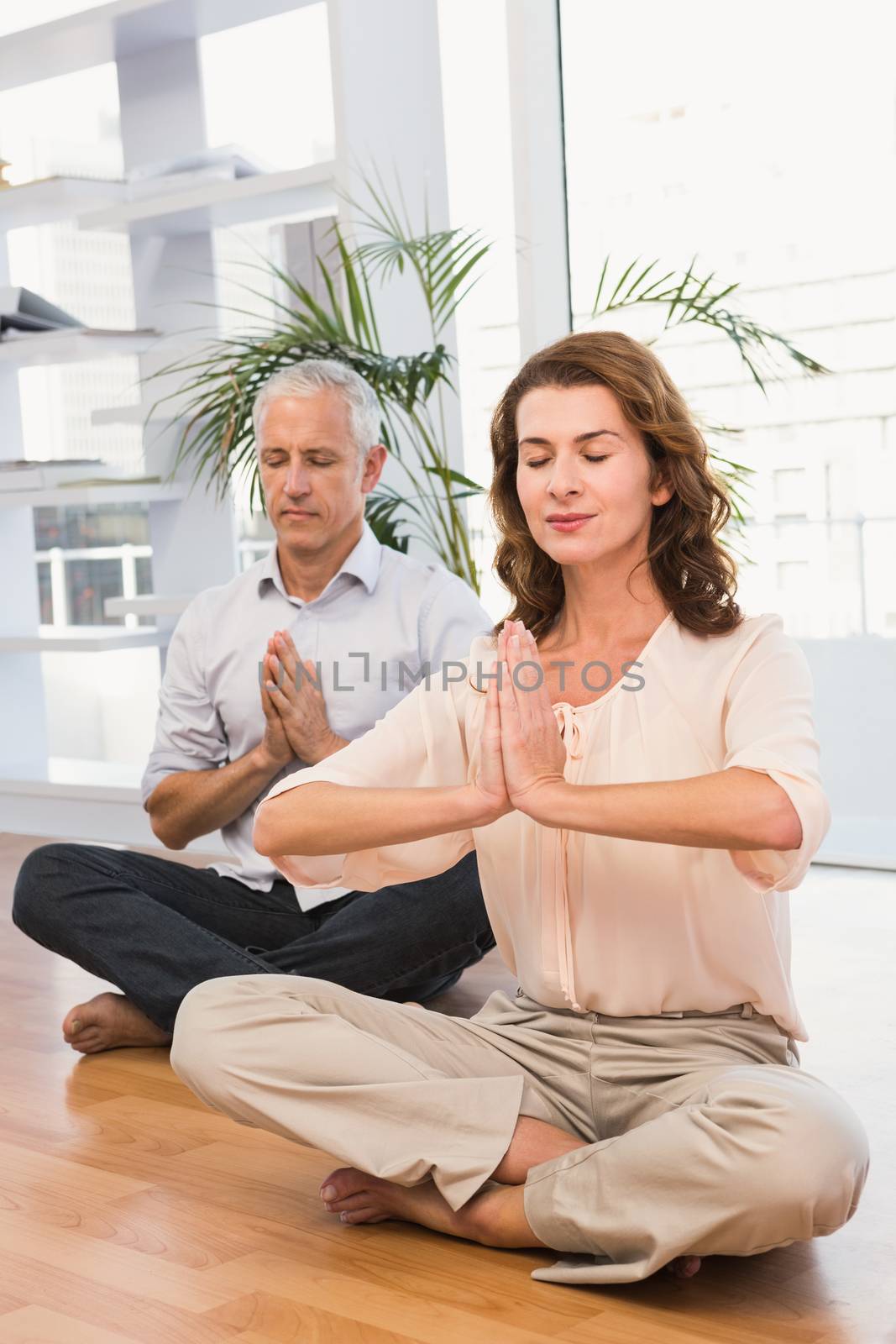Peaceful casual business colleagues meditating in the office