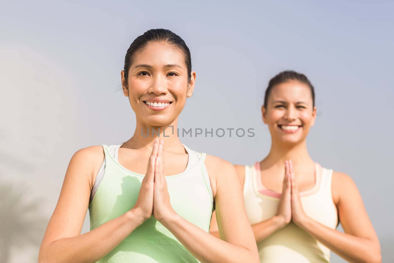 Smiling sporty women doing yoga in parkland