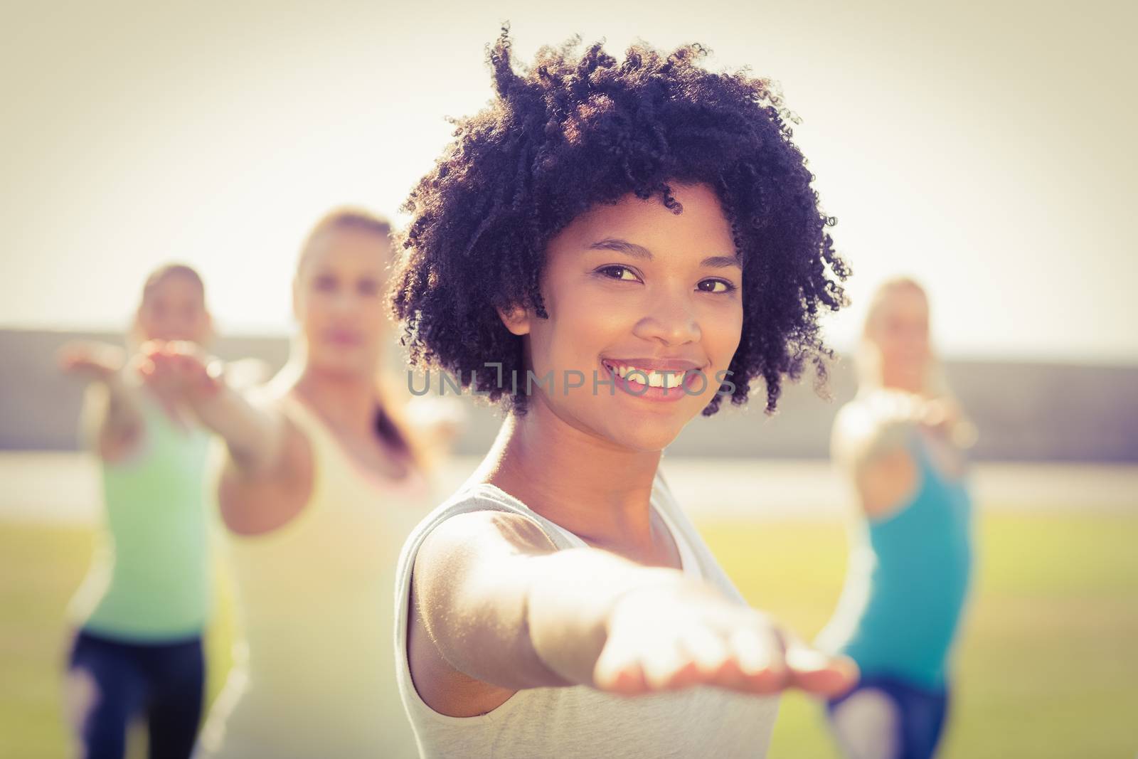 Portrait of smiling sporty woman doing yoga in yoga class in parkland
