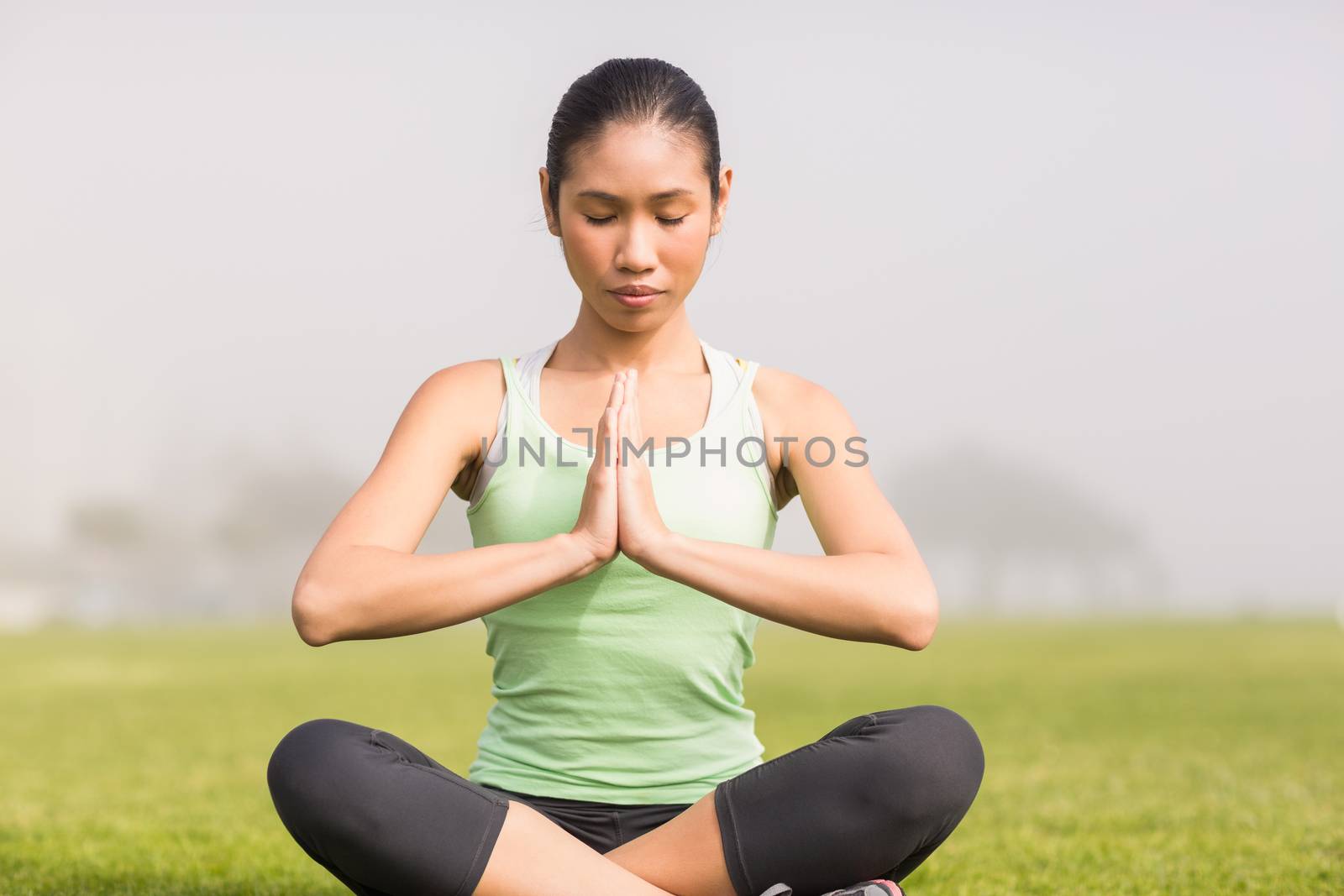 Peaceful sporty woman doing yoga in parkland