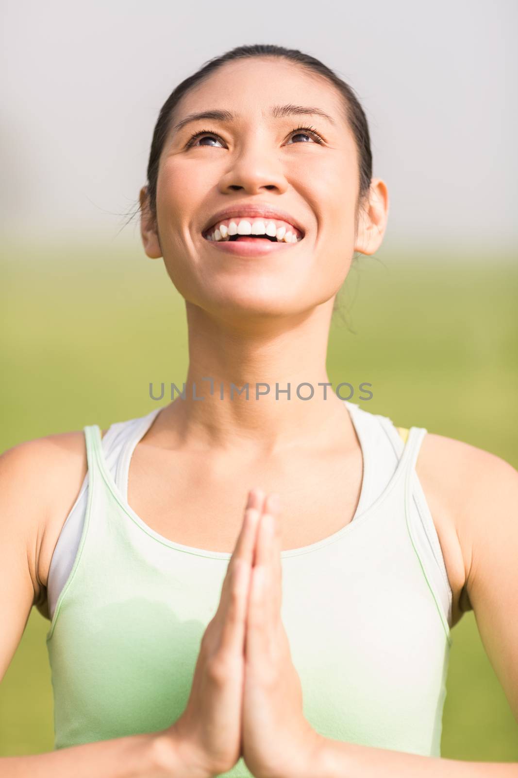 Smiling sporty woman doing yoga in parkland