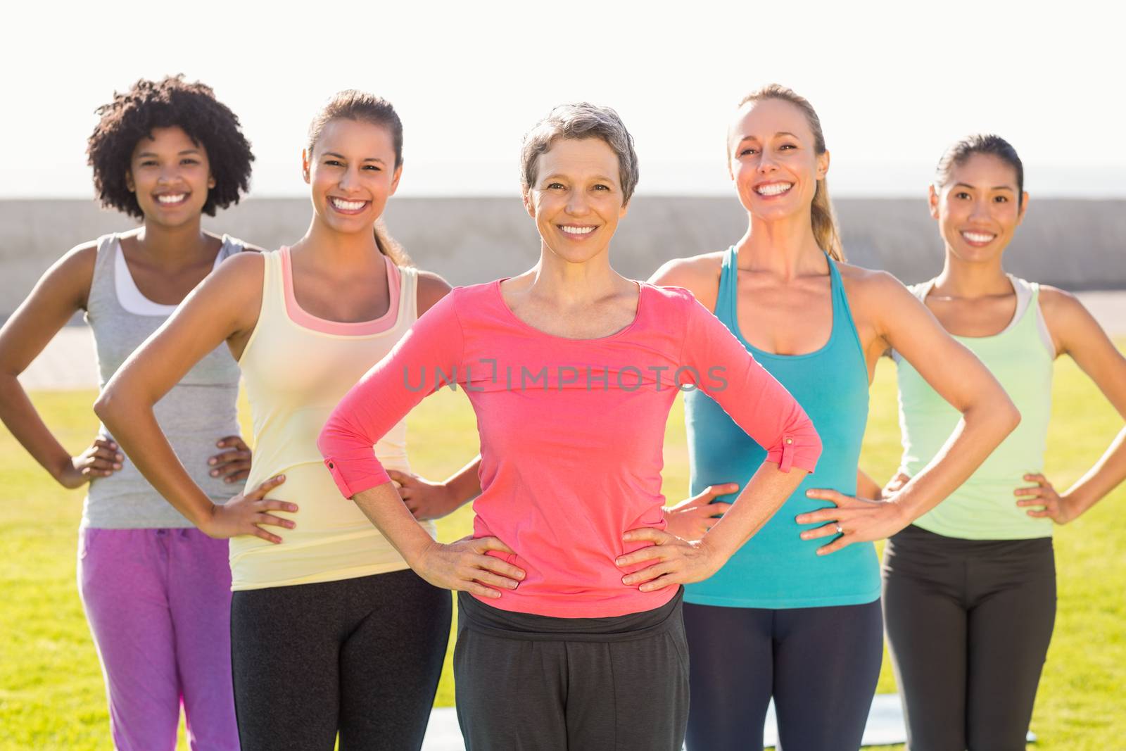 Smiling sporty women with hands on hips by Wavebreakmedia