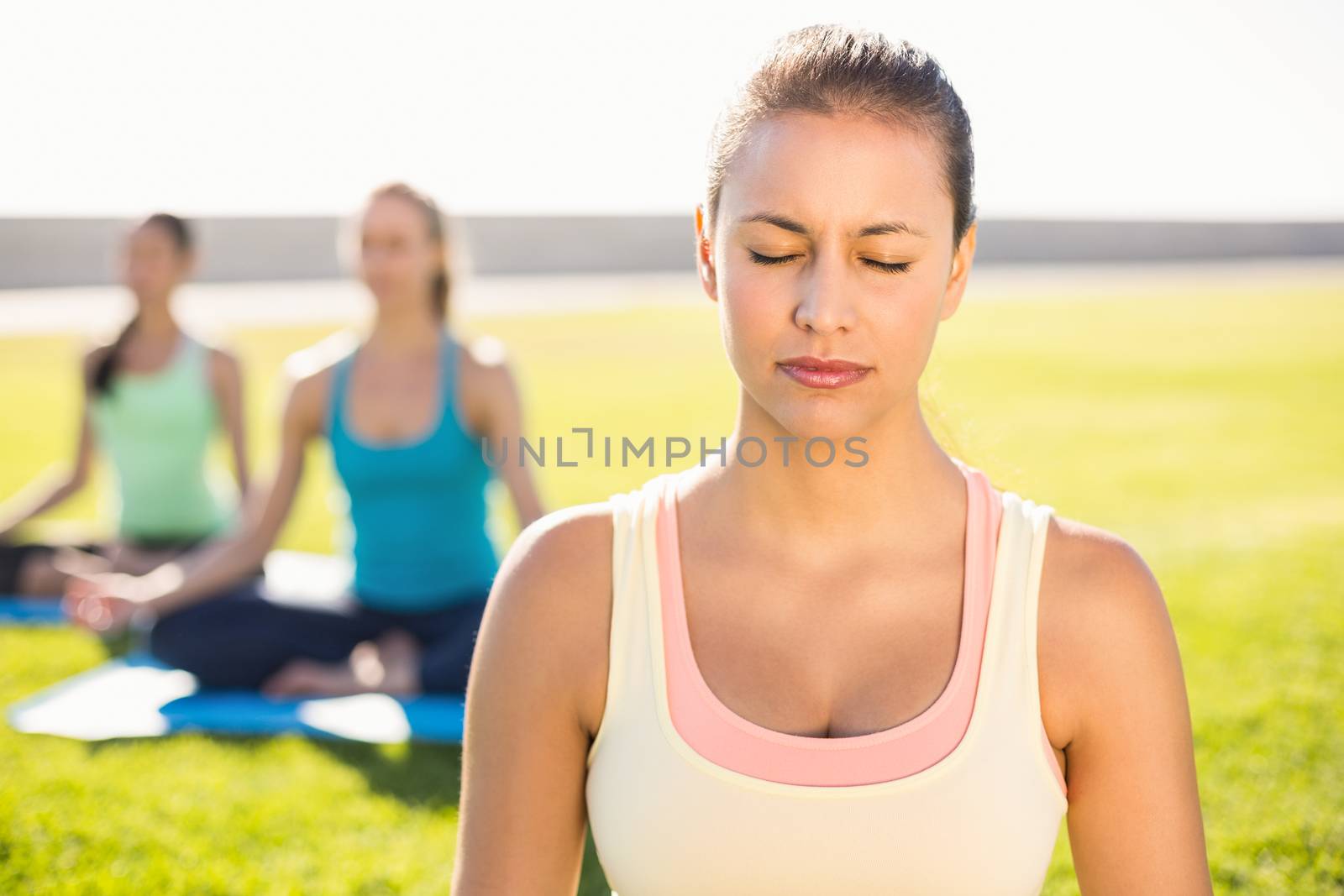 Peaceful sporty brunette doing yoga with her friends by Wavebreakmedia