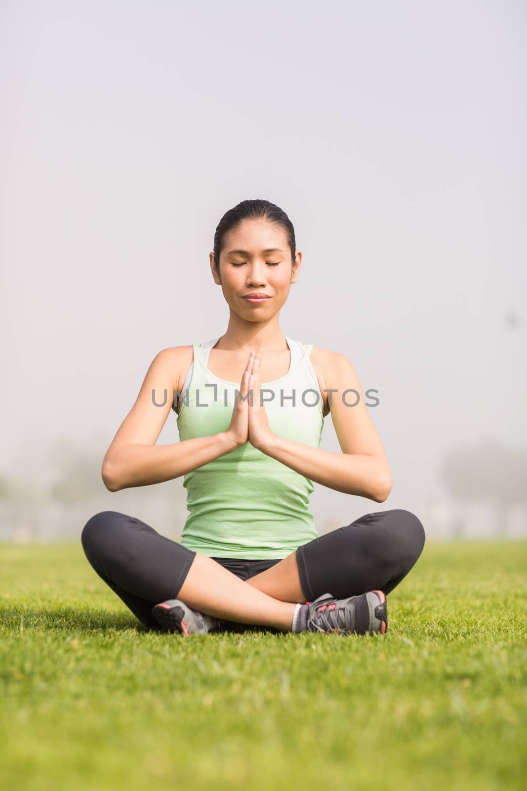 Peaceful sporty woman doing yoga in parkland