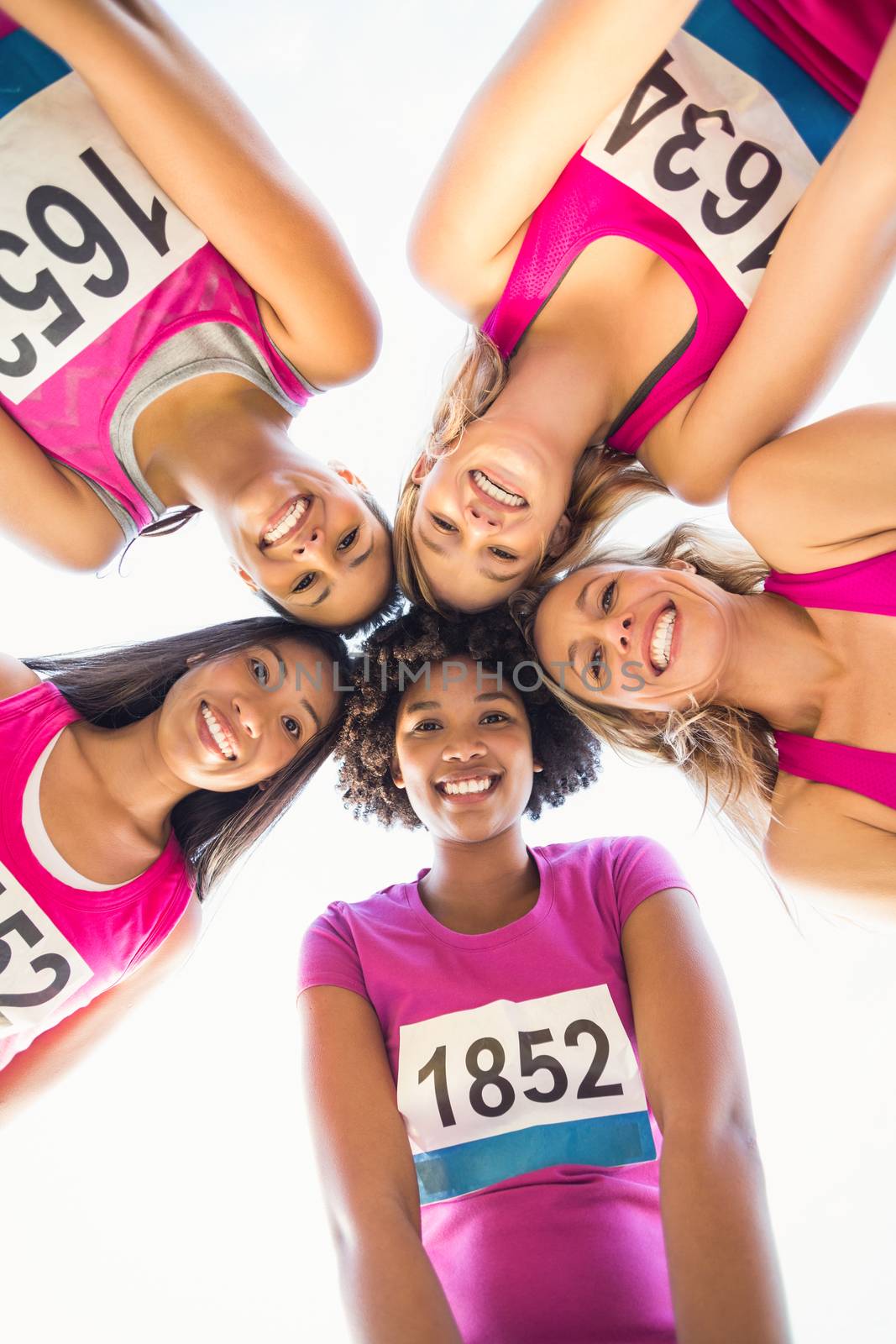 Five smiling runners supporting breast cancer marathon by Wavebreakmedia