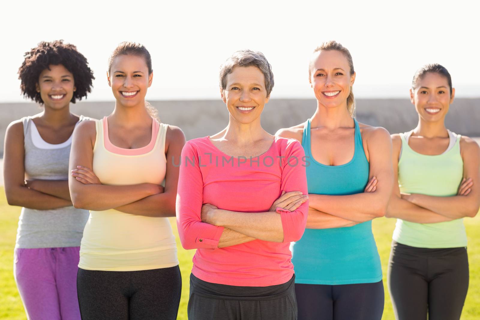 Portrait of smiling sporty women with arms crossed in parkland