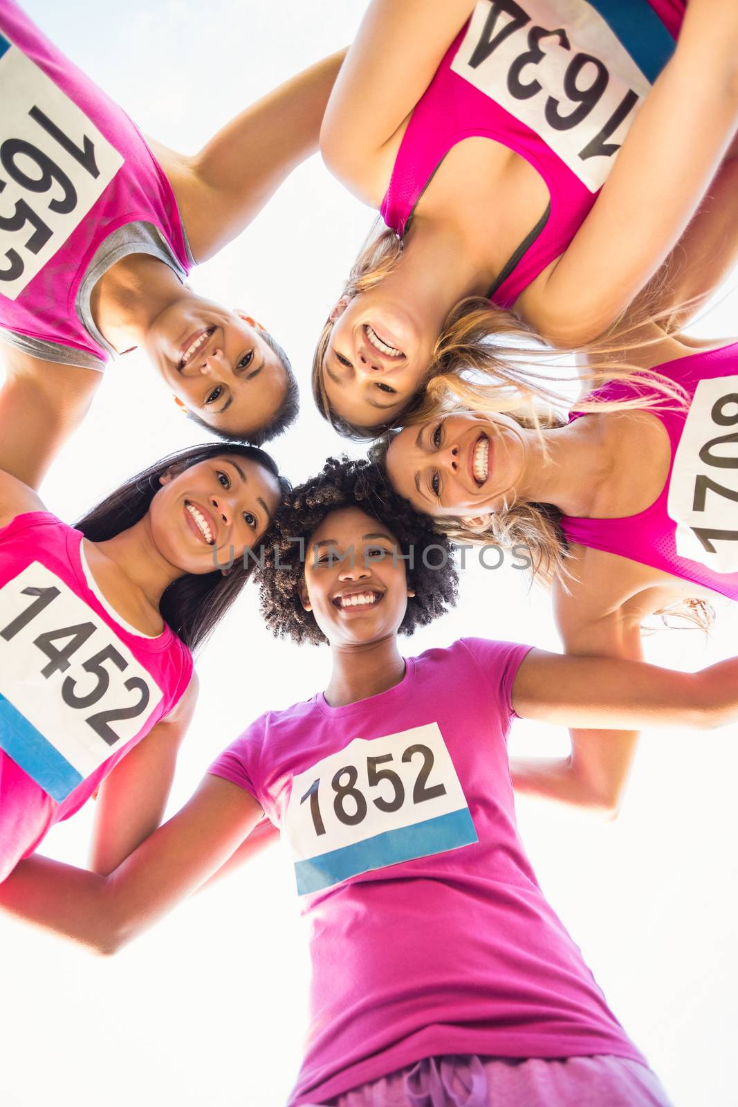 Five smiling runners supporting breast cancer marathon by Wavebreakmedia