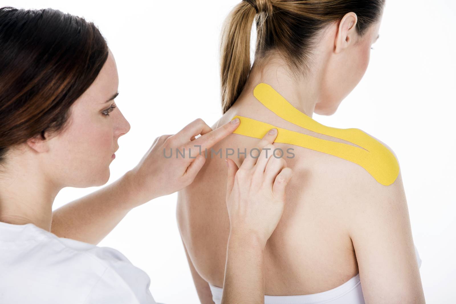 physiotherapist who puts the taping on the trapezius by Flareimage