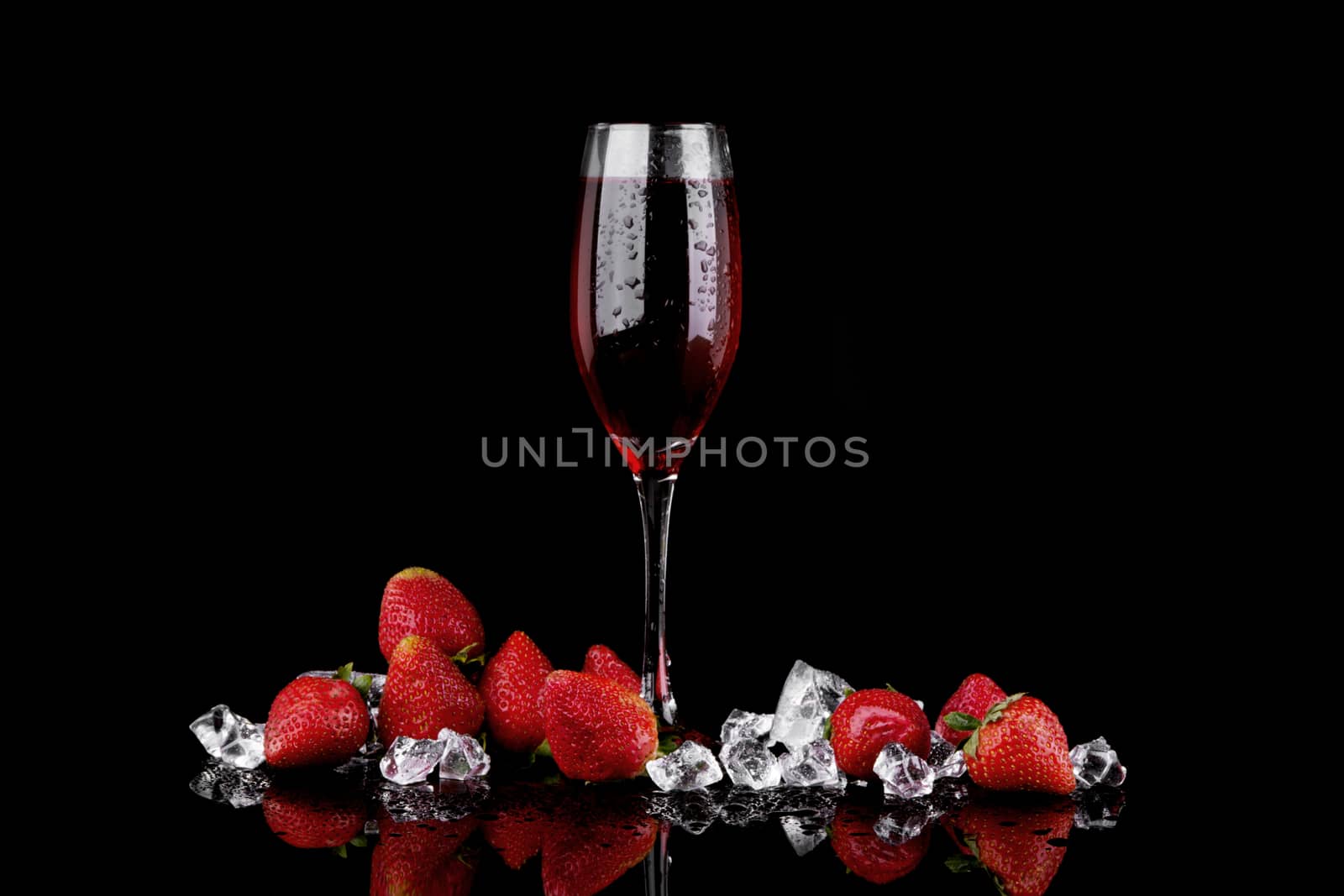 Red strawberry with glass of champagne on black background