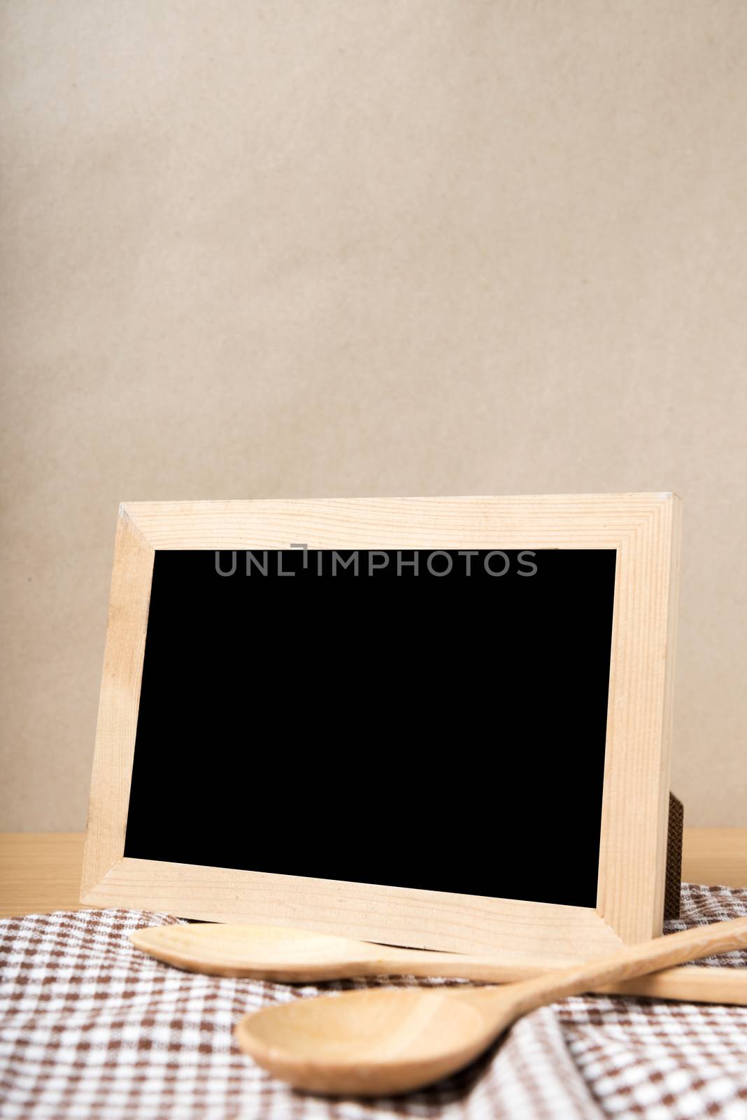 blackboard and wooden spoon on table