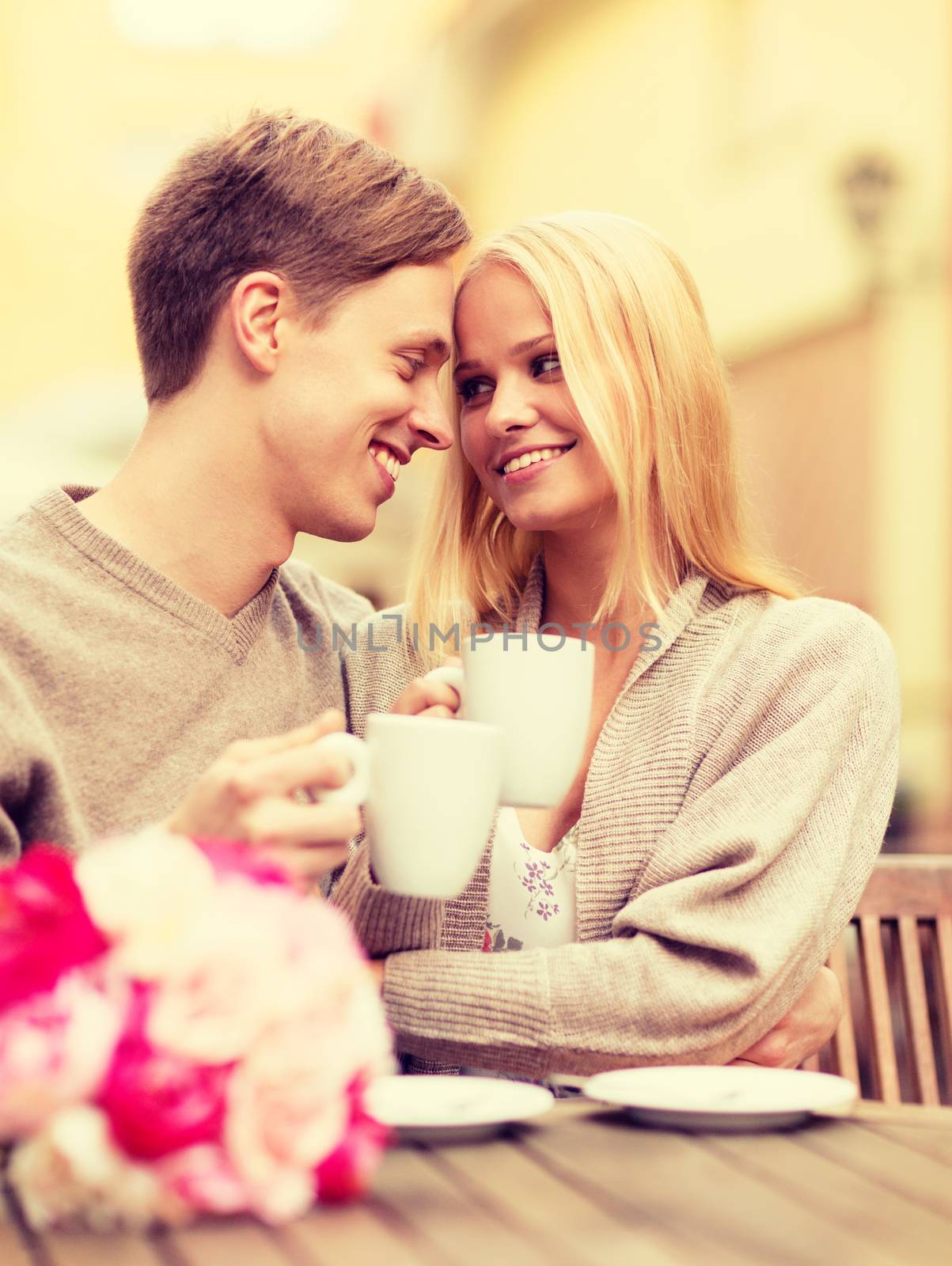 summer holidays, love, relationship and dating concept - romantic happy couple kissing in the cafe