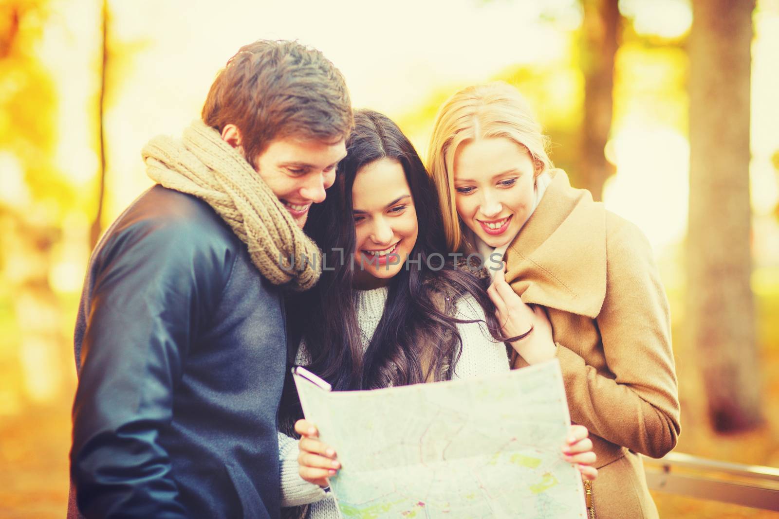 friends with tourist map in autumn park by dolgachov