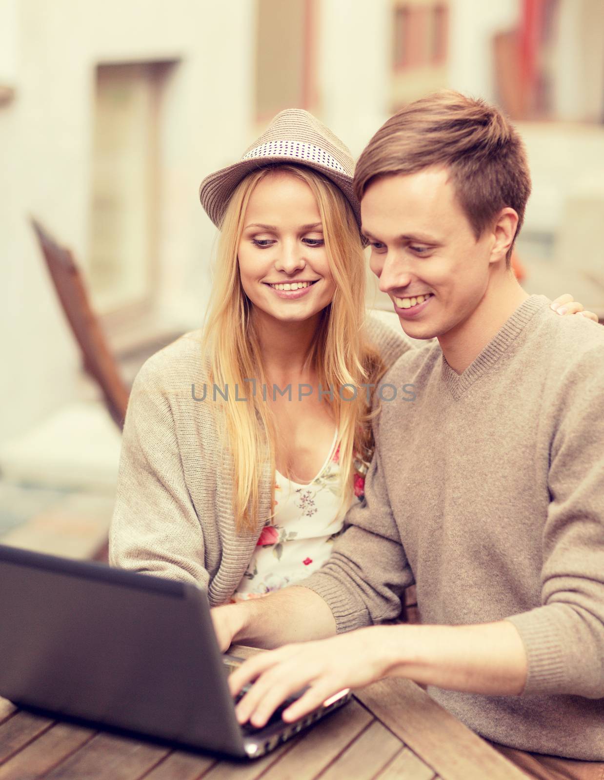 couple with laptop in cafe by dolgachov