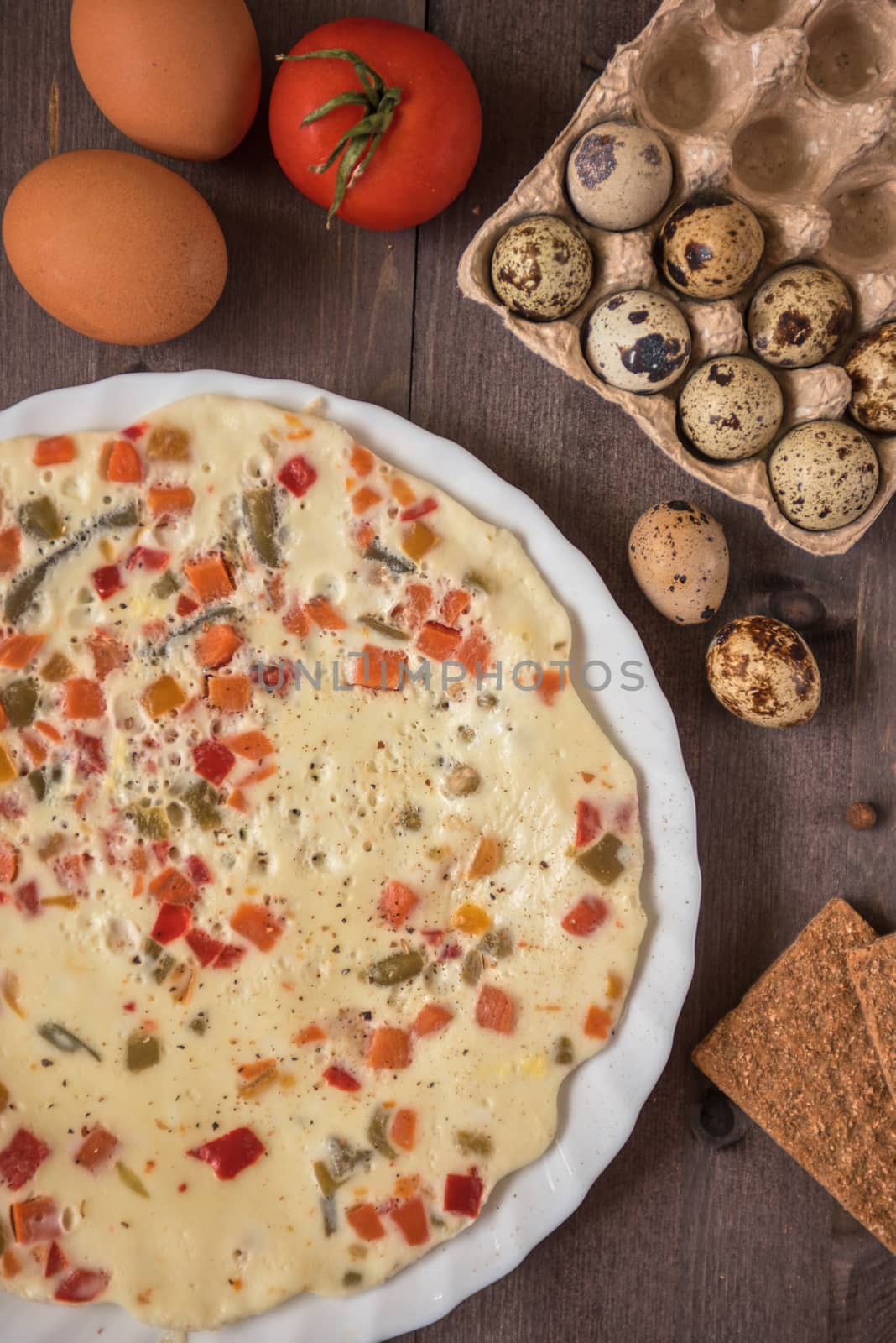 baked omelette with different eggs and vegetables with rye small load of bread