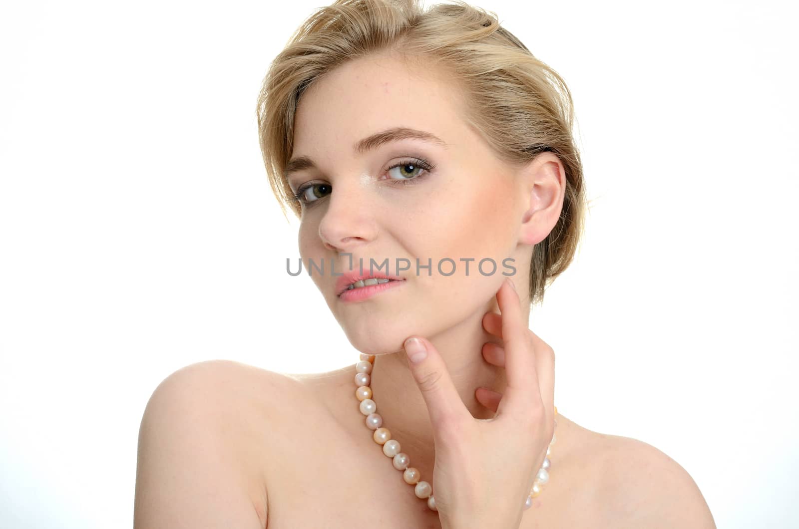 Beautiful female model with pearls on her neck. Portrait of young girl with soft and kind face expression.