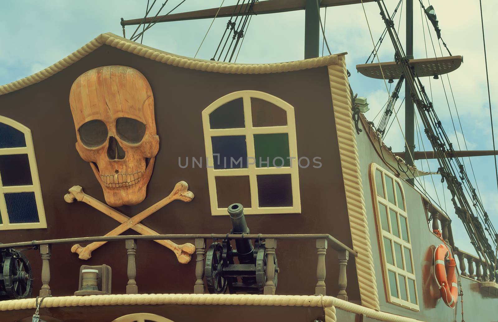 The photo shows a fragment of the stern of a yacht, with the image of a pirate symbols: skulls, crossbones, models of guns.