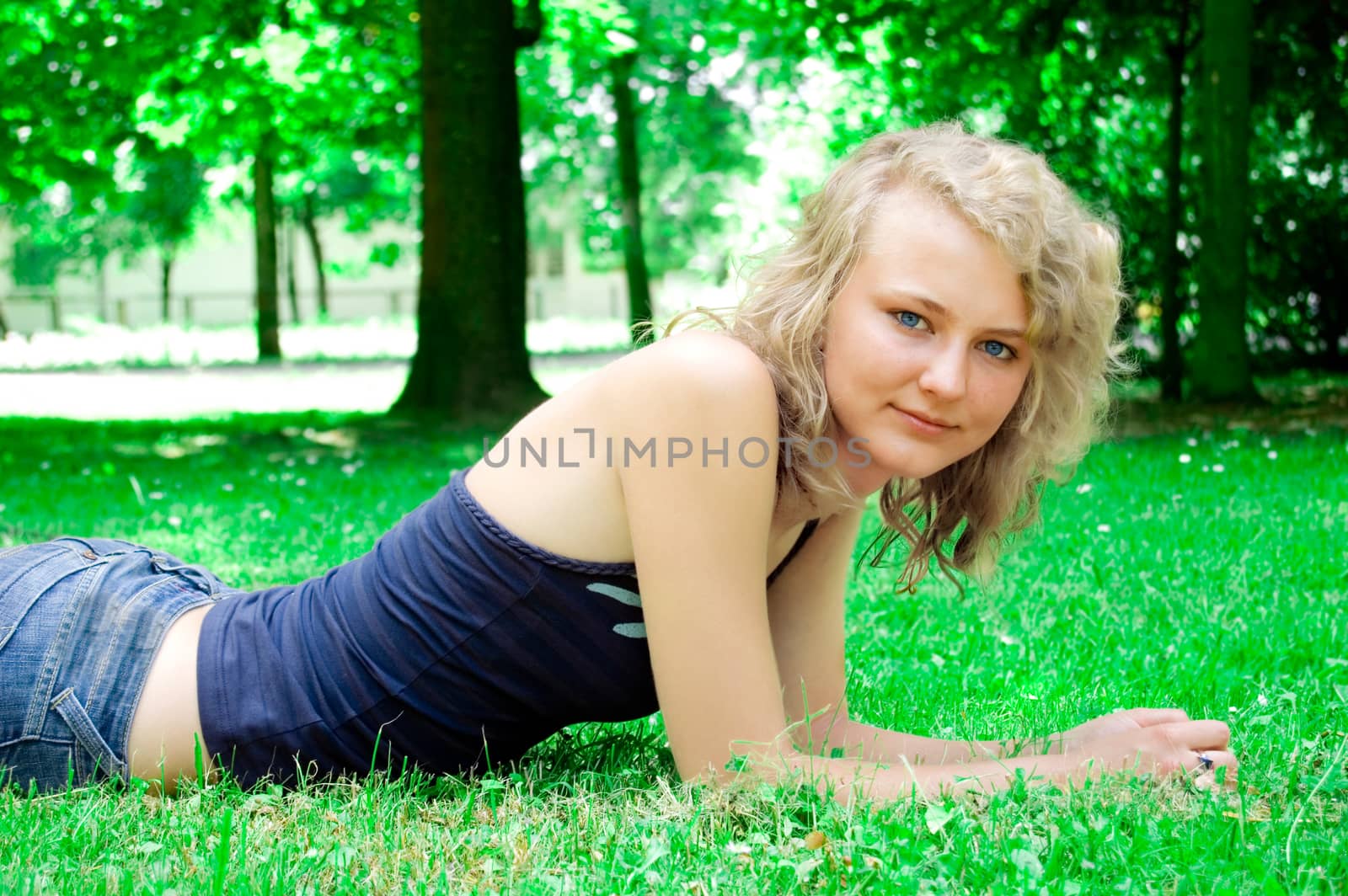 Young beautiful girl lies on the lawn.