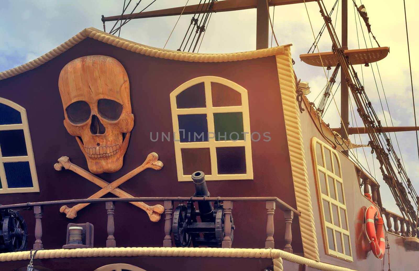 The photo shows a fragment of the stern of a yacht, with the image of a pirate symbols: skulls, crossbones, models of guns.