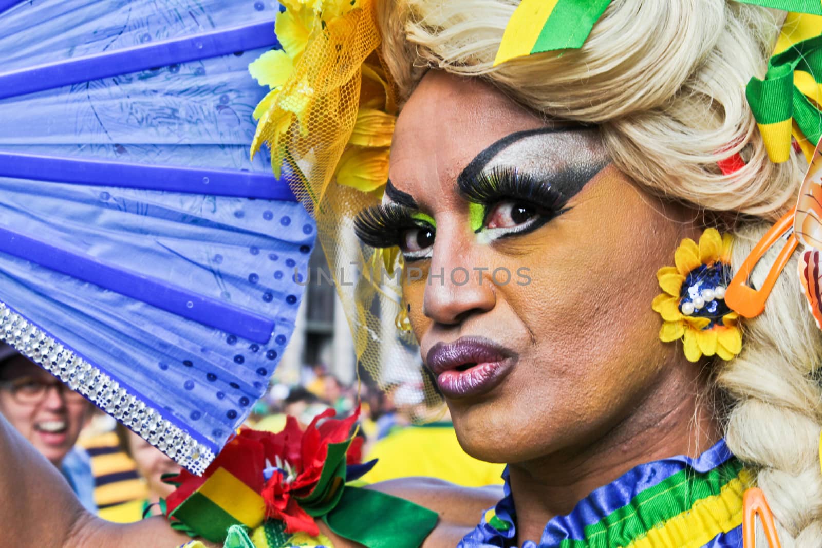 SAO PAULO, BRAZIL August 16, 2015: A drag queen called Charlene Blue with yellow and green costume poses for pictures and selfies in the protest against federal government corruption in Sao Paulo Brazil.