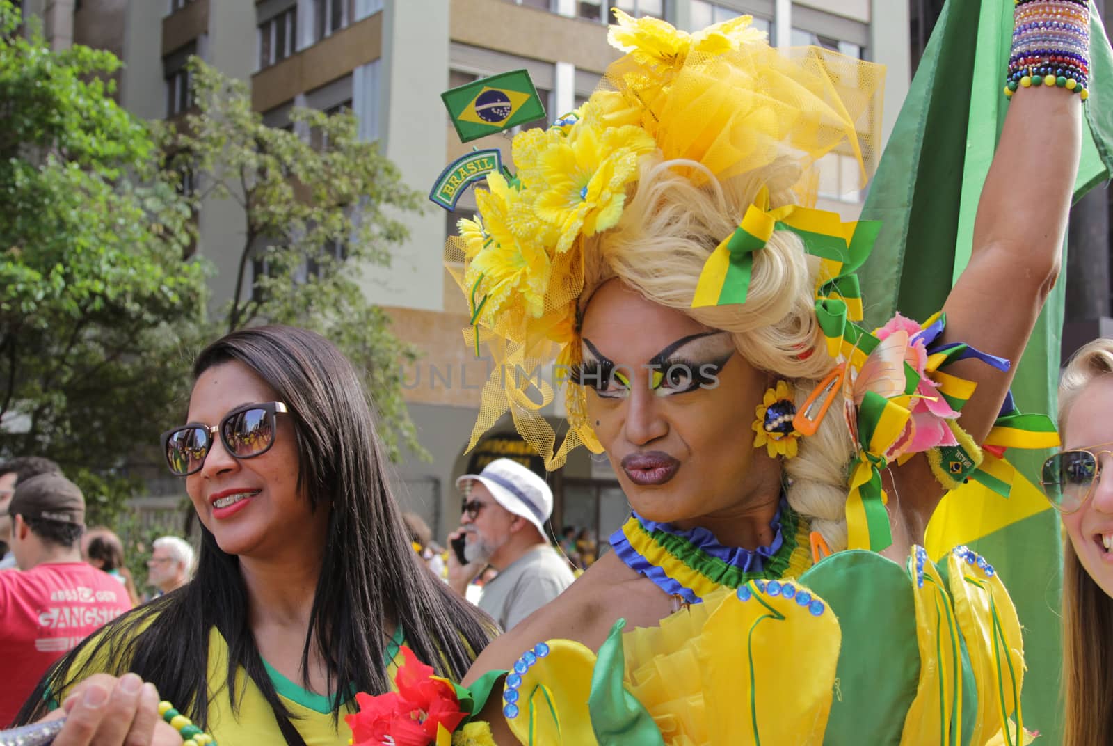 SAO PAULO, BRAZIL August 16, 2015: A drag queen called Charlene Blue with yellow and green costume poses for pictures and selfies in the protest against federal government corruption in Sao Paulo Brazil.