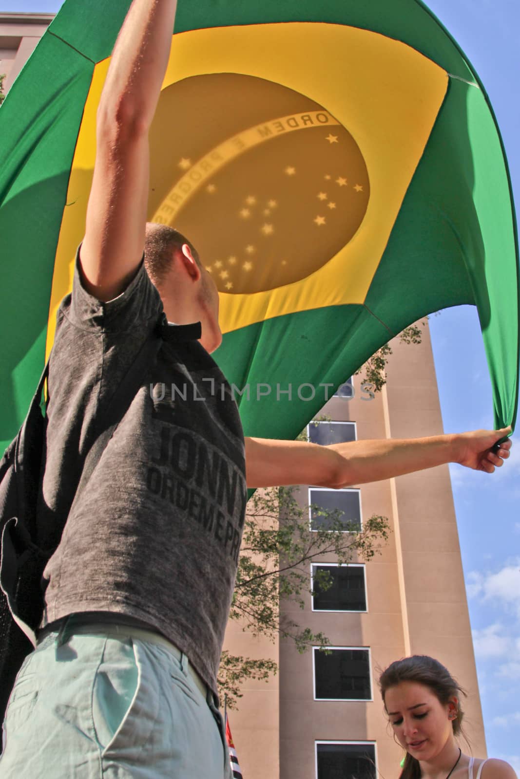 SAO PAULO, BRAZIL August 16, 2015: An unidentified man with a flag in the protest against federal government corruption in Sao Paulo Brazil.