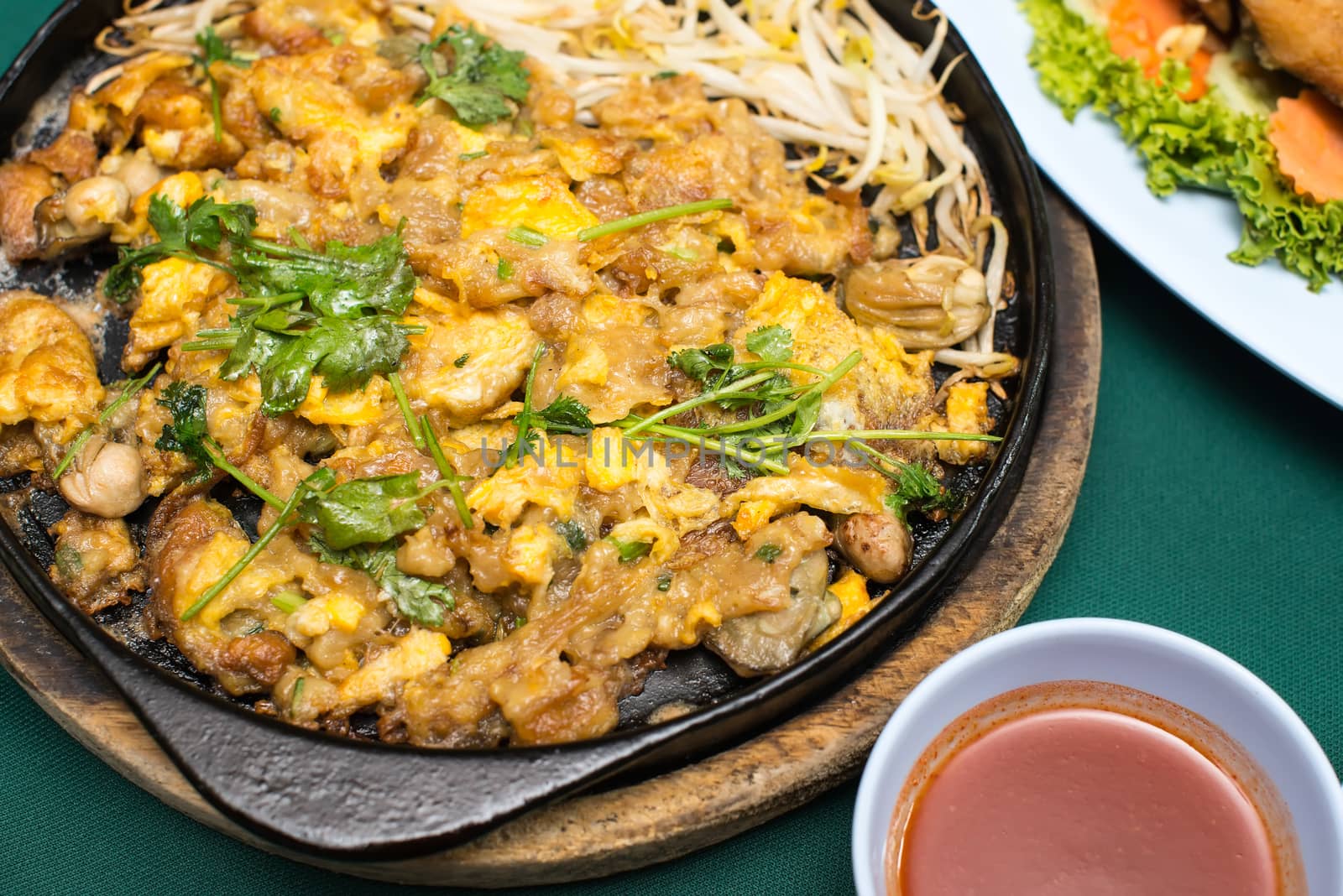 Thai food, fried mussel pancake in hot pan by Yuri2012