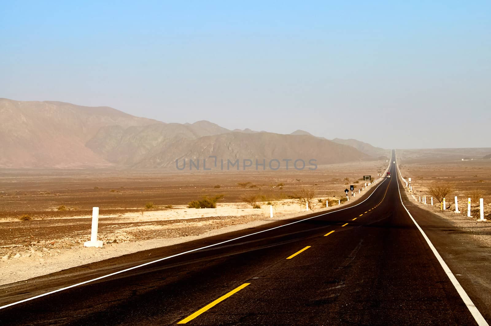 Long dirty black road in Peru desert  valley