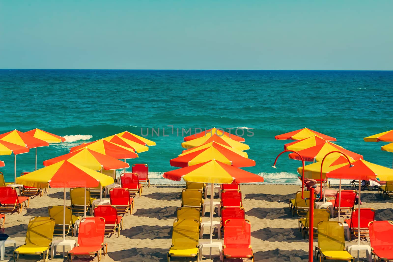 Umbrellas for sun protection and sun loungers on the deserted beach because of the storm .On waves of the sea.